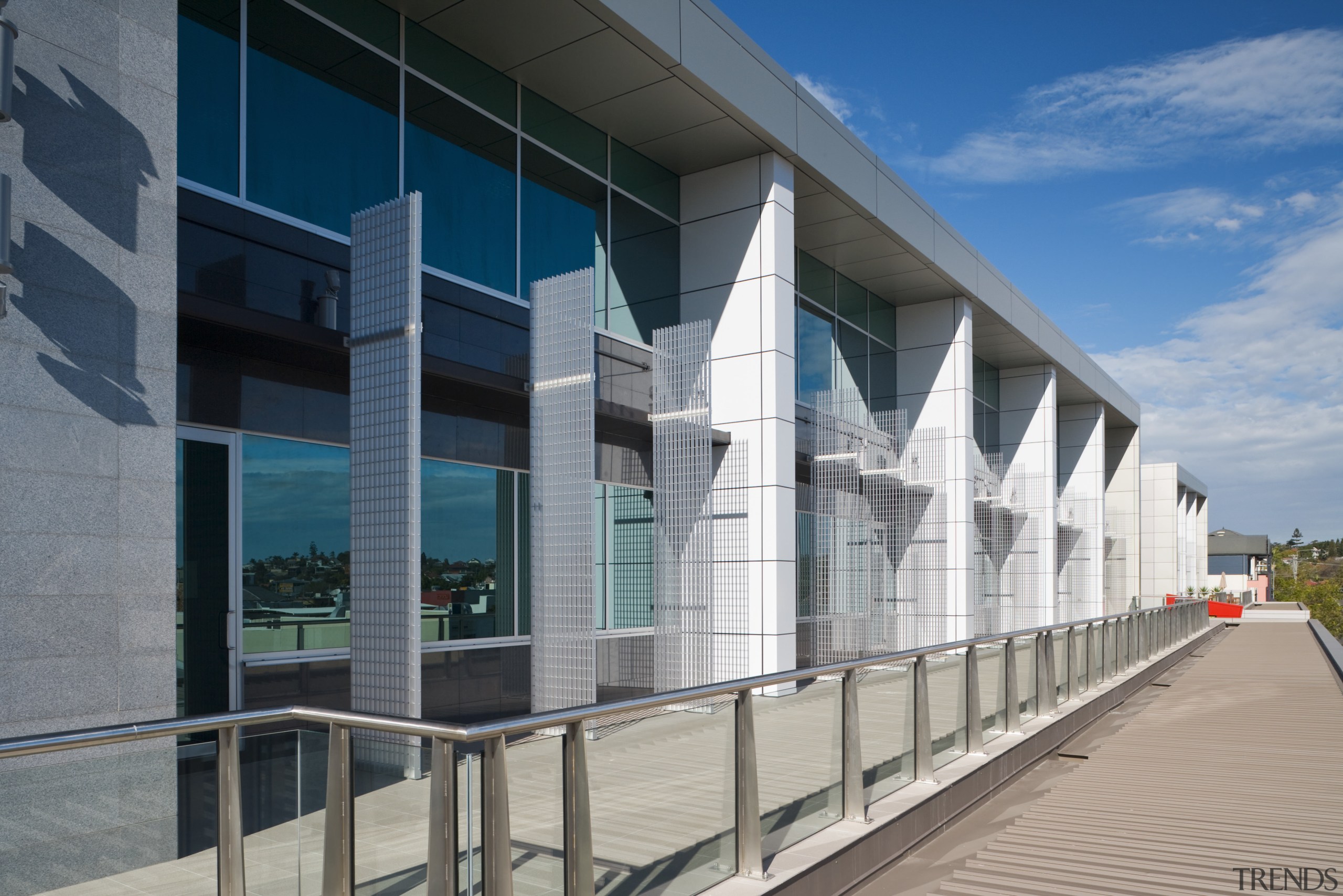 View of an office building featuring glazing which apartment, architecture, building, commercial building, condominium, corporate headquarters, facade, headquarters, metropolitan area, mixed use, real estate, residential area, structure, window, gray