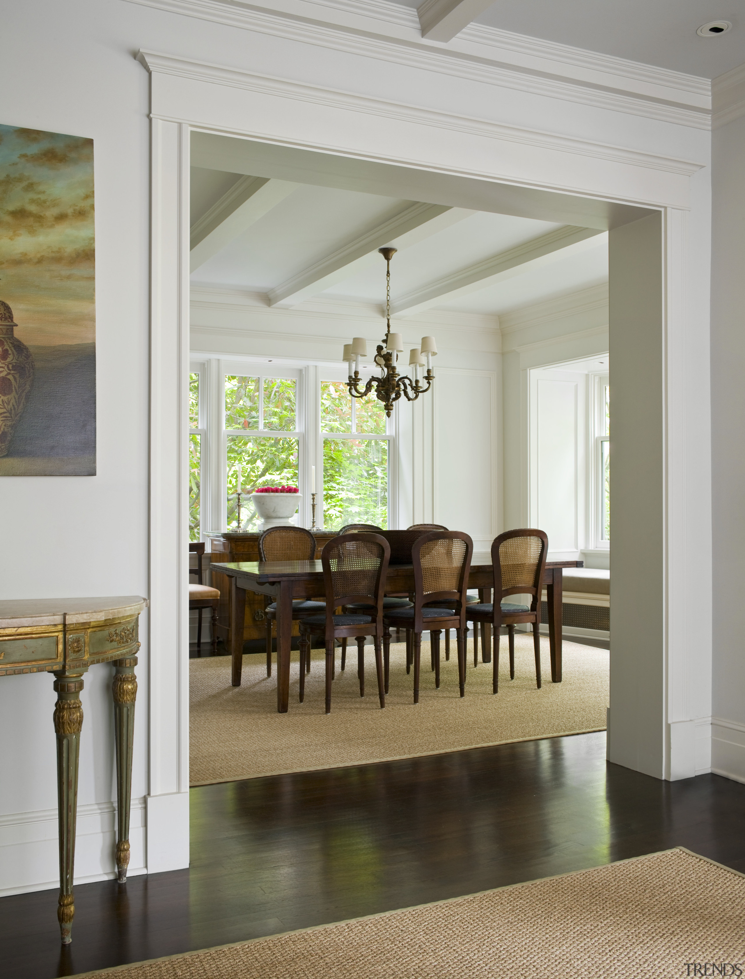 View of dining room which features a chandelier, ceiling, chair, dining room, door, floor, flooring, furniture, hardwood, home, interior design, living room, room, table, wall, window, wood flooring, gray