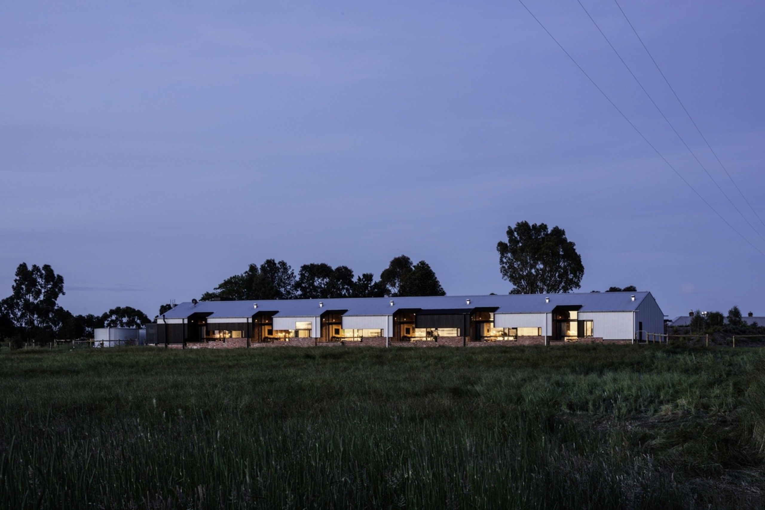 A view of the entire complex at night architecture, cloud, dawn, dusk, energy, evening, farm, field, grass, grassland, home, horizon, house, landscape, morning, plain, plant, prairie, real estate, residential area, rural area, sky, suburb, tree, blue, black