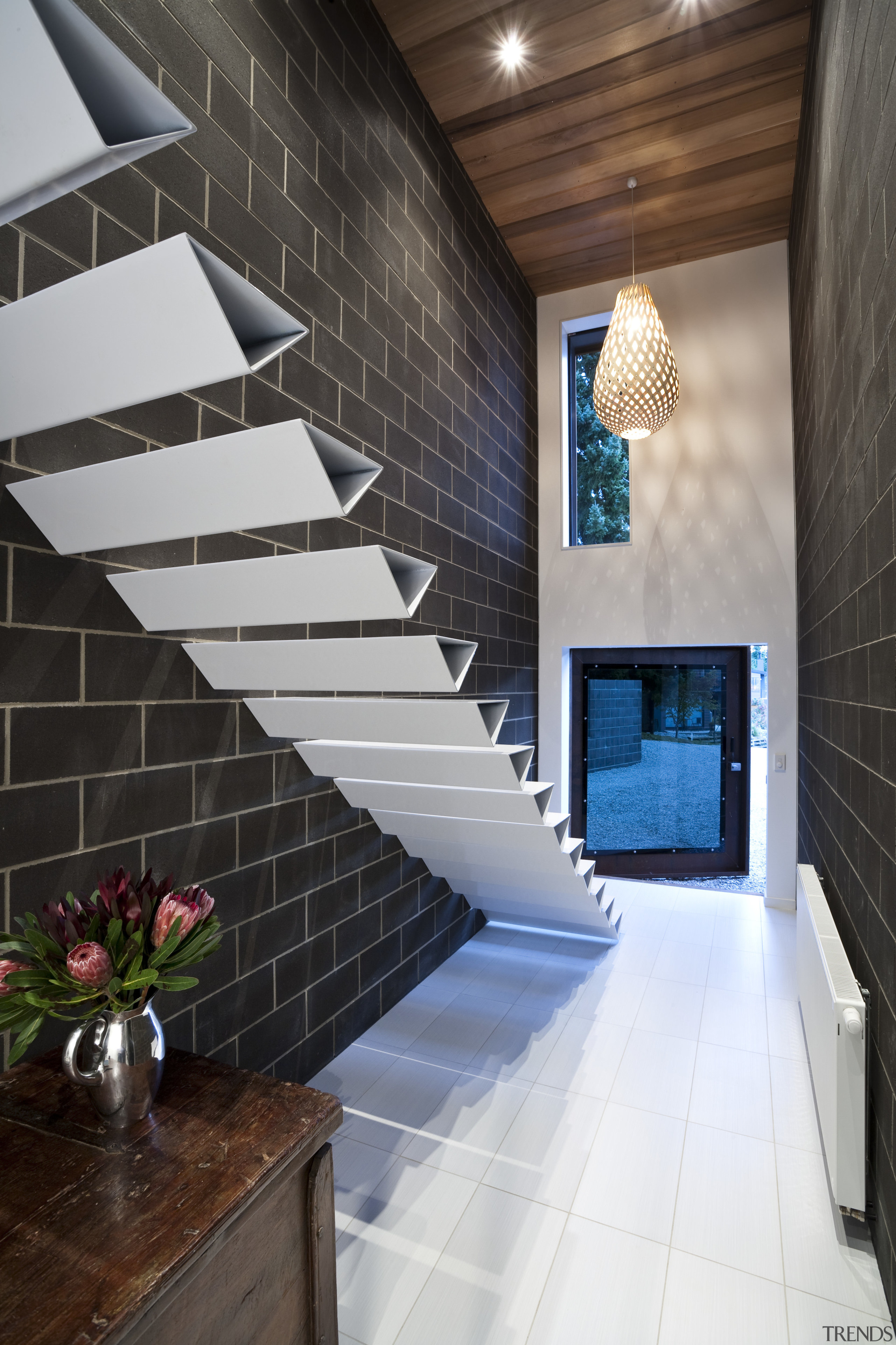 View of cantilevered, triangular-shaped steel stairs, tiled floors, apartment, architecture, ceiling, daylighting, estate, floor, flooring, handrail, home, house, interior design, lobby, real estate, room, stairs, tile, wall, black