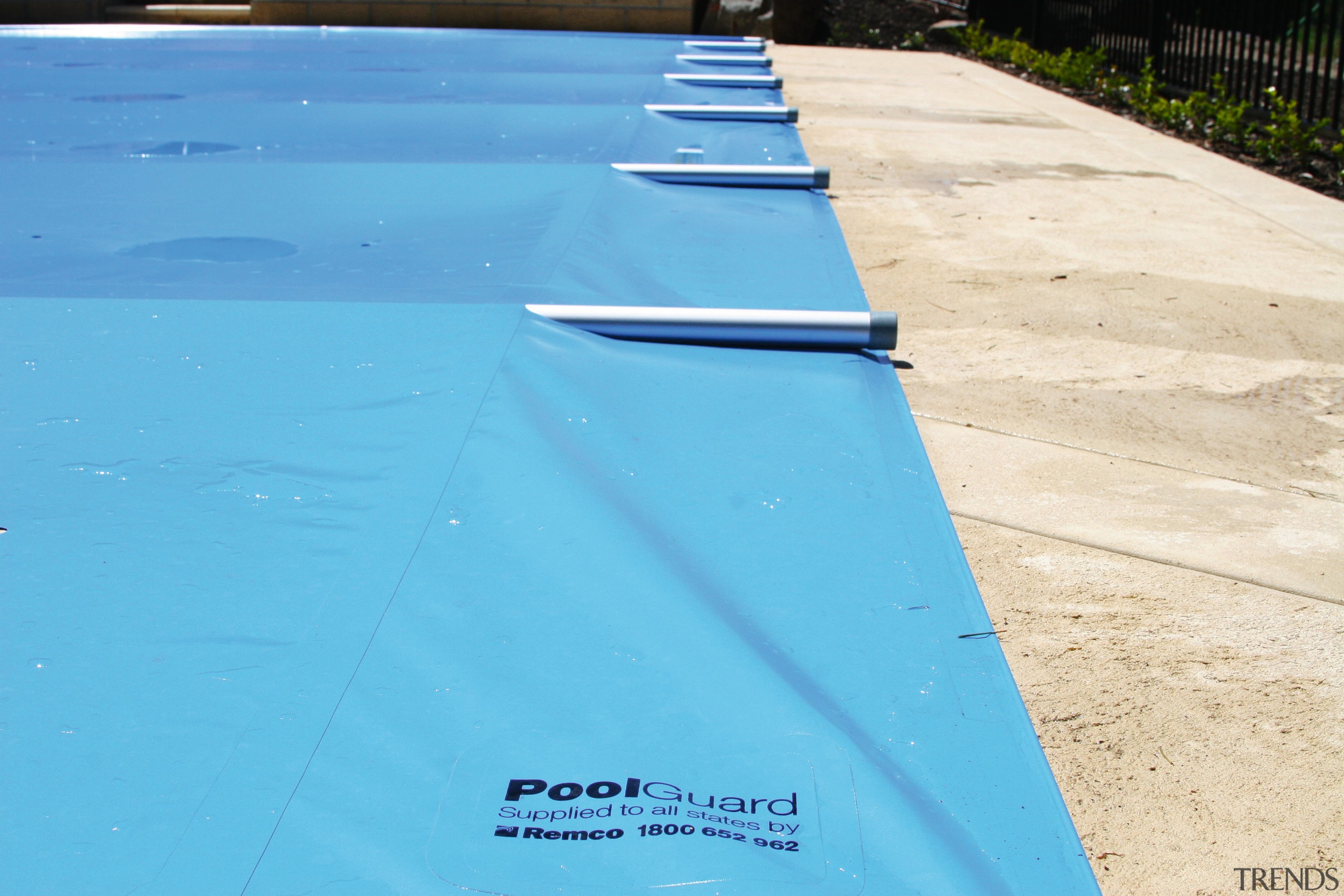 Blue swimming pool cover with aluminium tubes. - aqua, azure, blue, green, line, sky, swimming pool, tarpaulin, turquoise, water, wood, teal, orange