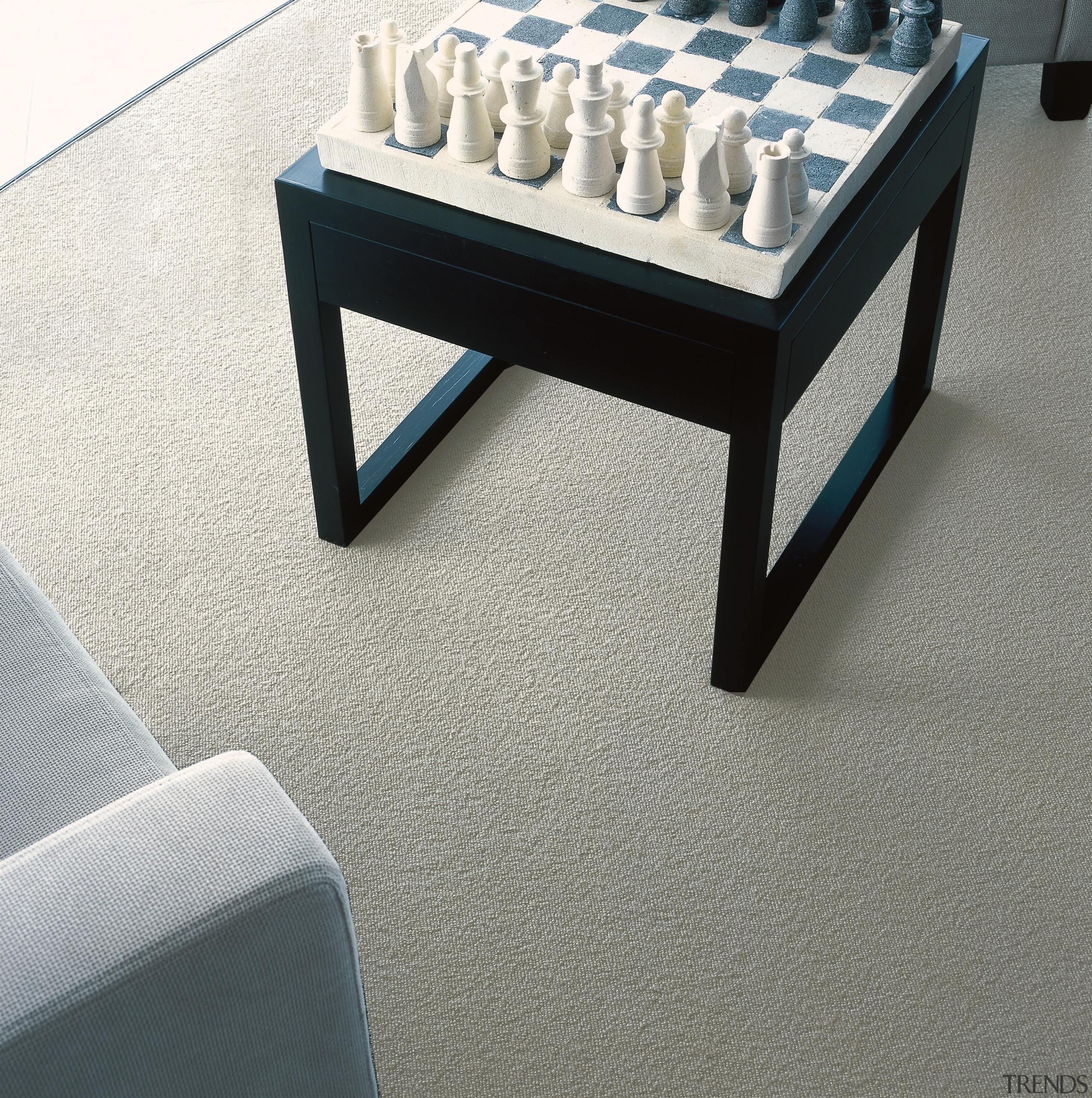 Black stool with chess set on natural coloured coffee table, floor, flooring, furniture, product design, table, gray, white