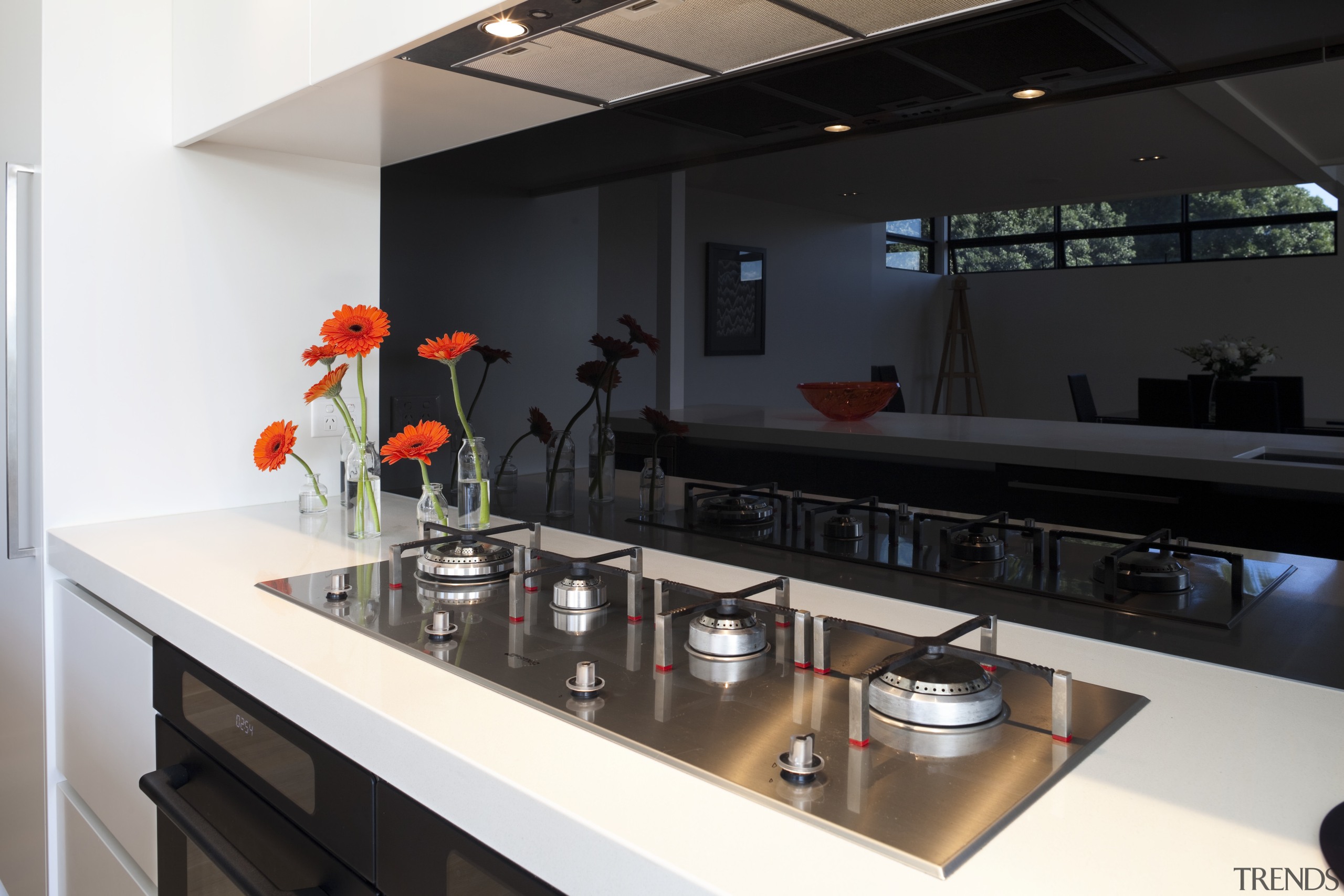 View of cooktop on white bench with black countertop, glass, interior design, kitchen, black, white