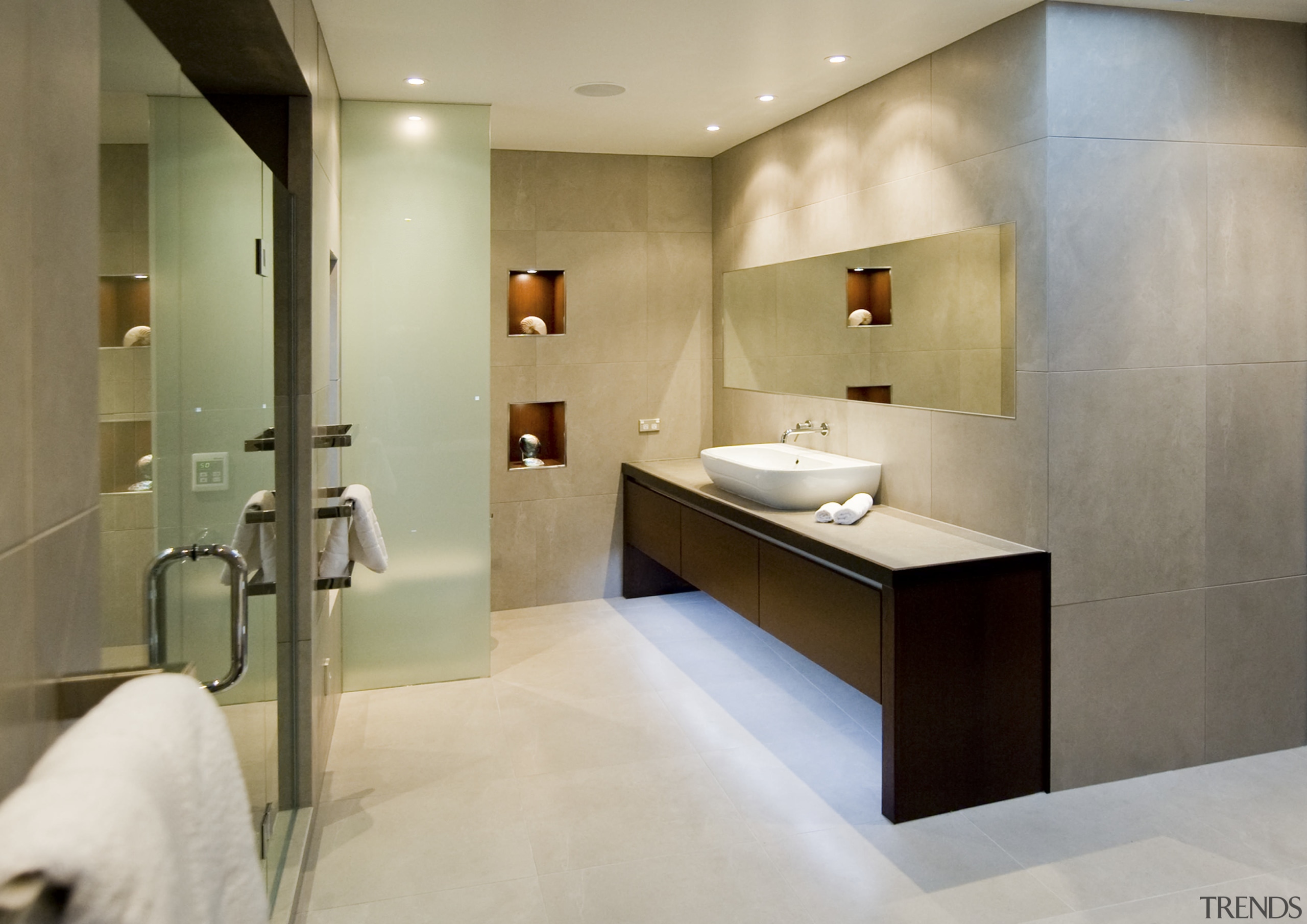 View of a bathroom featuring vanity, tiling, shower bathroom, floor, flooring, interior design, product design, room, sink, tile, gray, brown