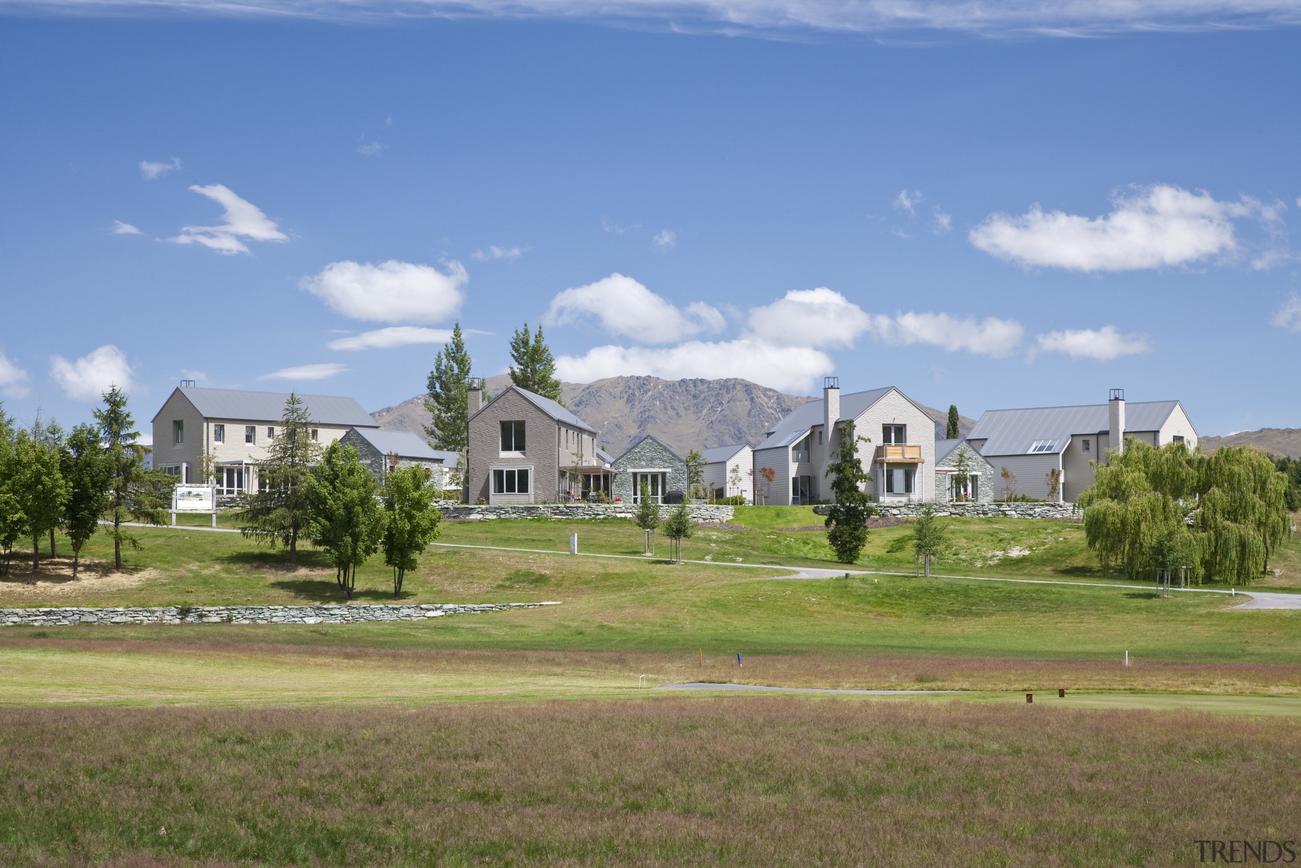 Exterior view of a home which features a cloud, cottage, daytime, estate, farm, farmhouse, field, grass, grassland, home, house, land lot, landscape, lawn, mansion, meadow, neighbourhood, property, real estate, residential area, rural area, sky, suburb, tree, village, teal, brown