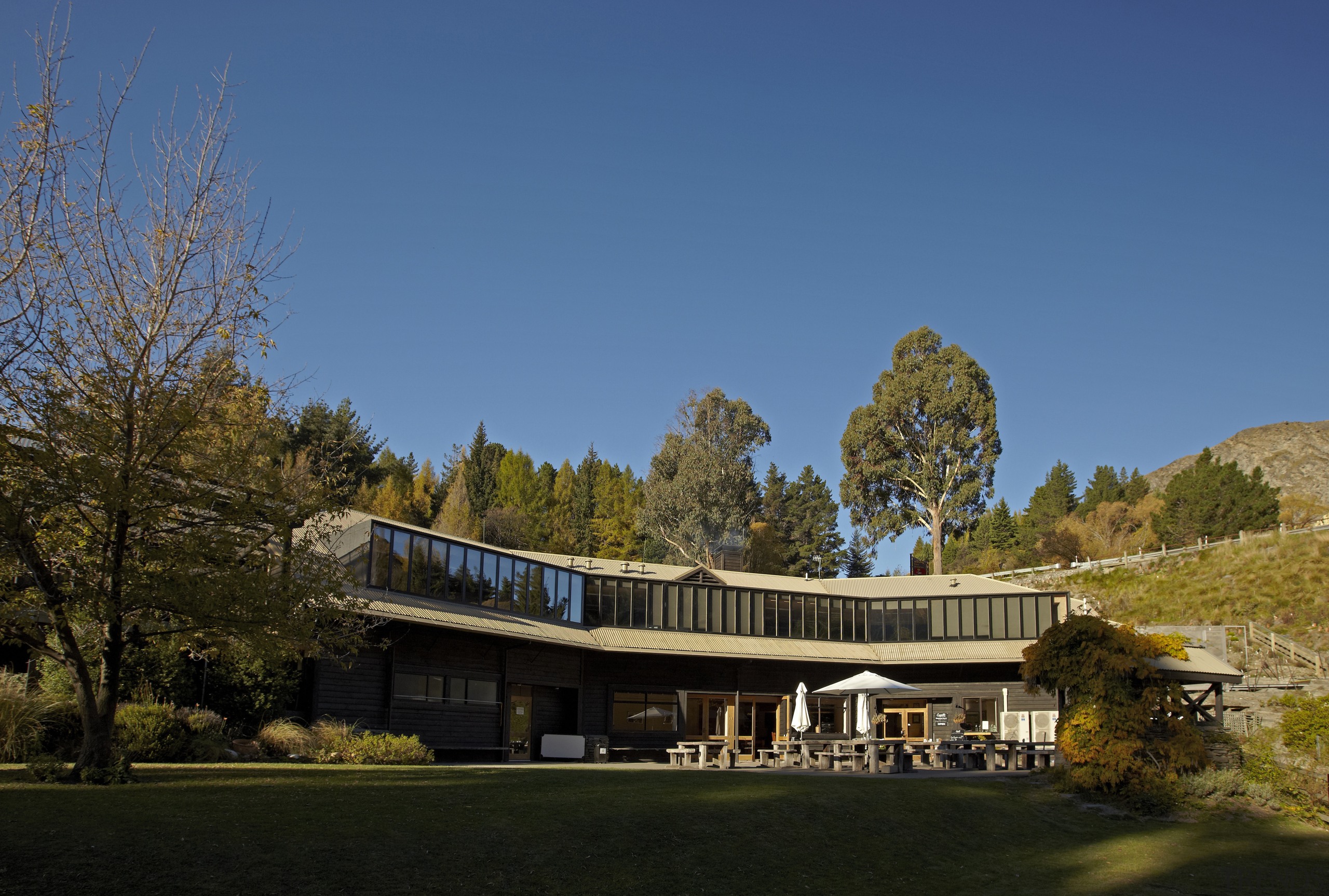 View of DOC building with neutral toned interior architecture, building, estate, home, house, landscape, nature, plant, real estate, residential area, sky, structure, tree, blue