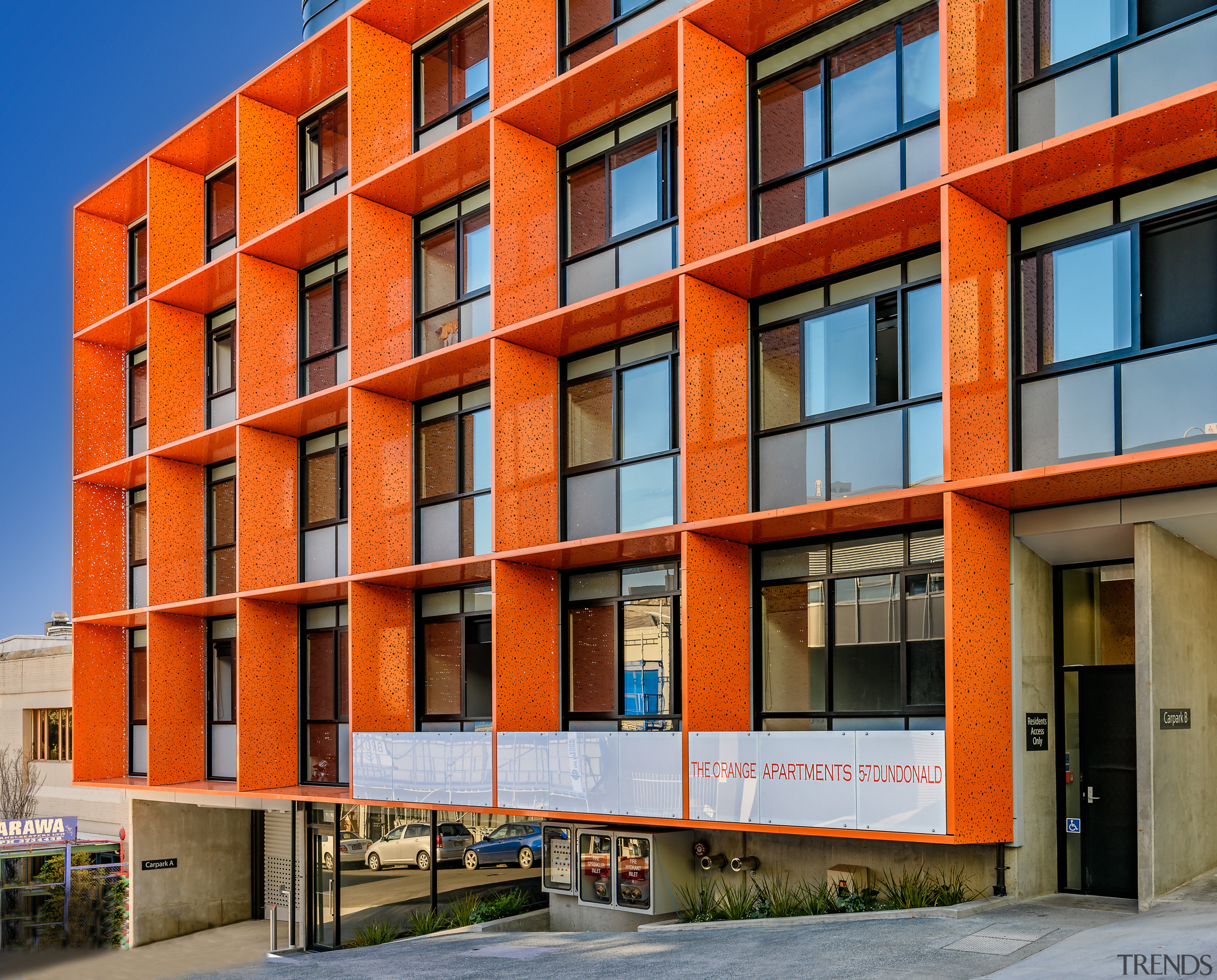 The Orange apartments feature a distinctive vibrant facade apartment, architecture, building, city, commercial building, condominium, corporate headquarters, elevation, facade, home, house, metropolitan area, mixed use, neighbourhood, real estate, residential area, tower block, urban area, window, red