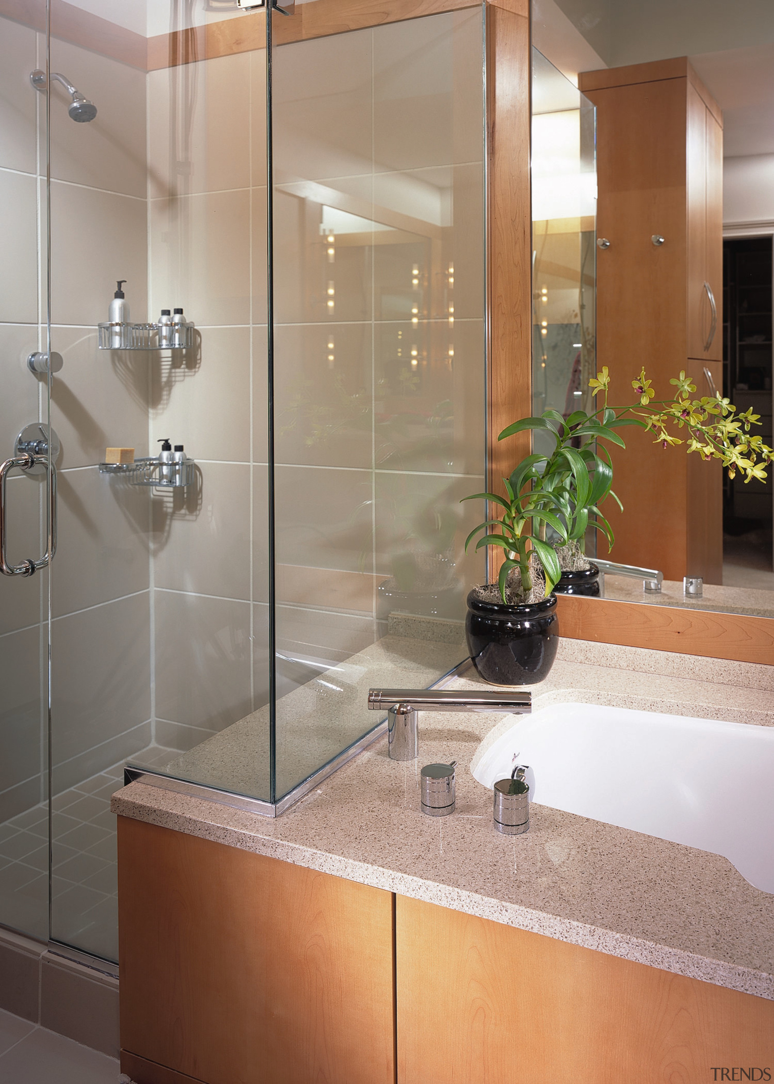 view of this bathroom featuring timber veneer cabinetry, bathroom, glass, interior design, plumbing fixture, room, sink, tile, gray