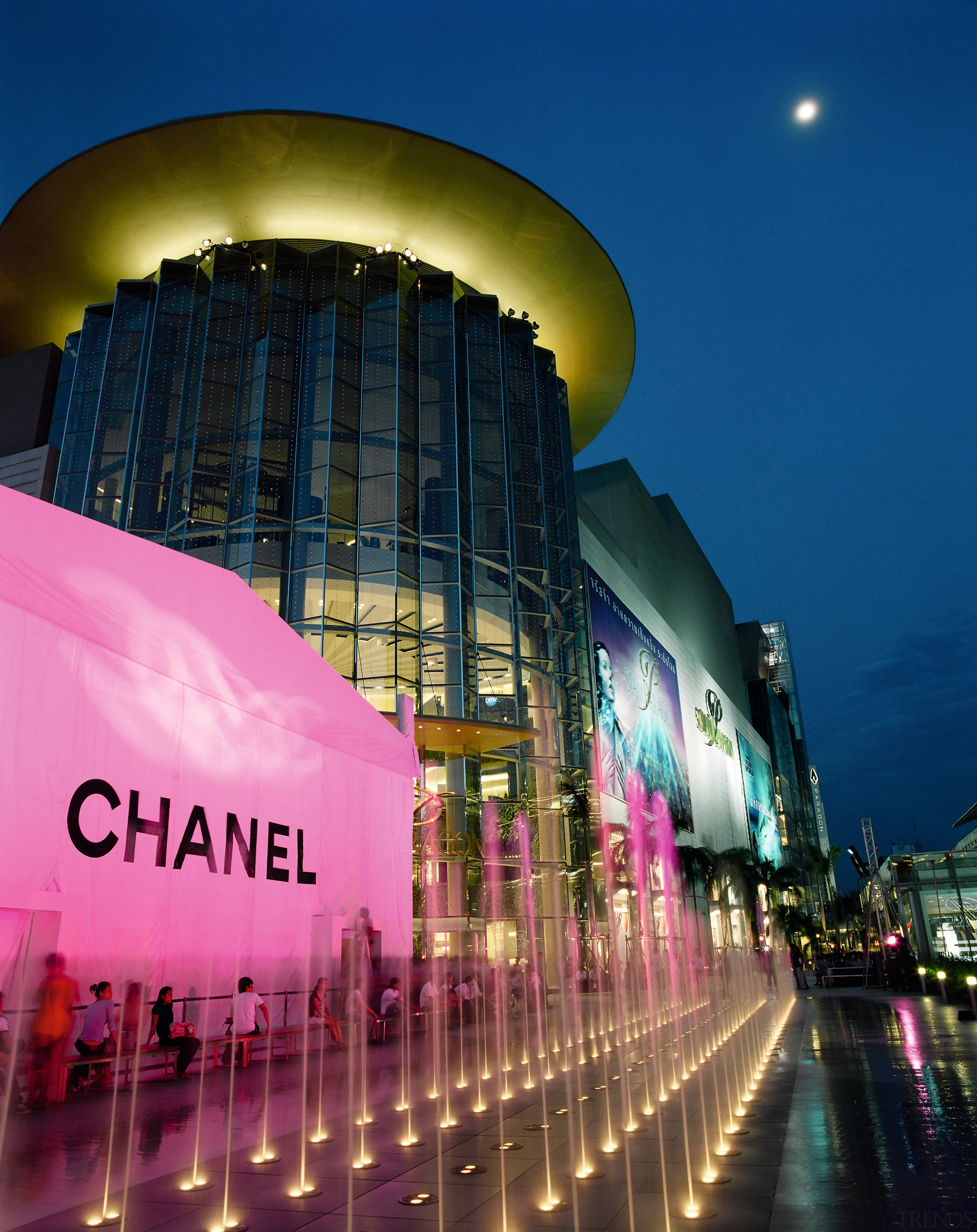 An exterior view of a shopping mall. - architecture, building, city, cityscape, downtown, landmark, light, lighting, metropolis, metropolitan area, mixed use, night, reflection, sky, structure, tourist attraction, blue