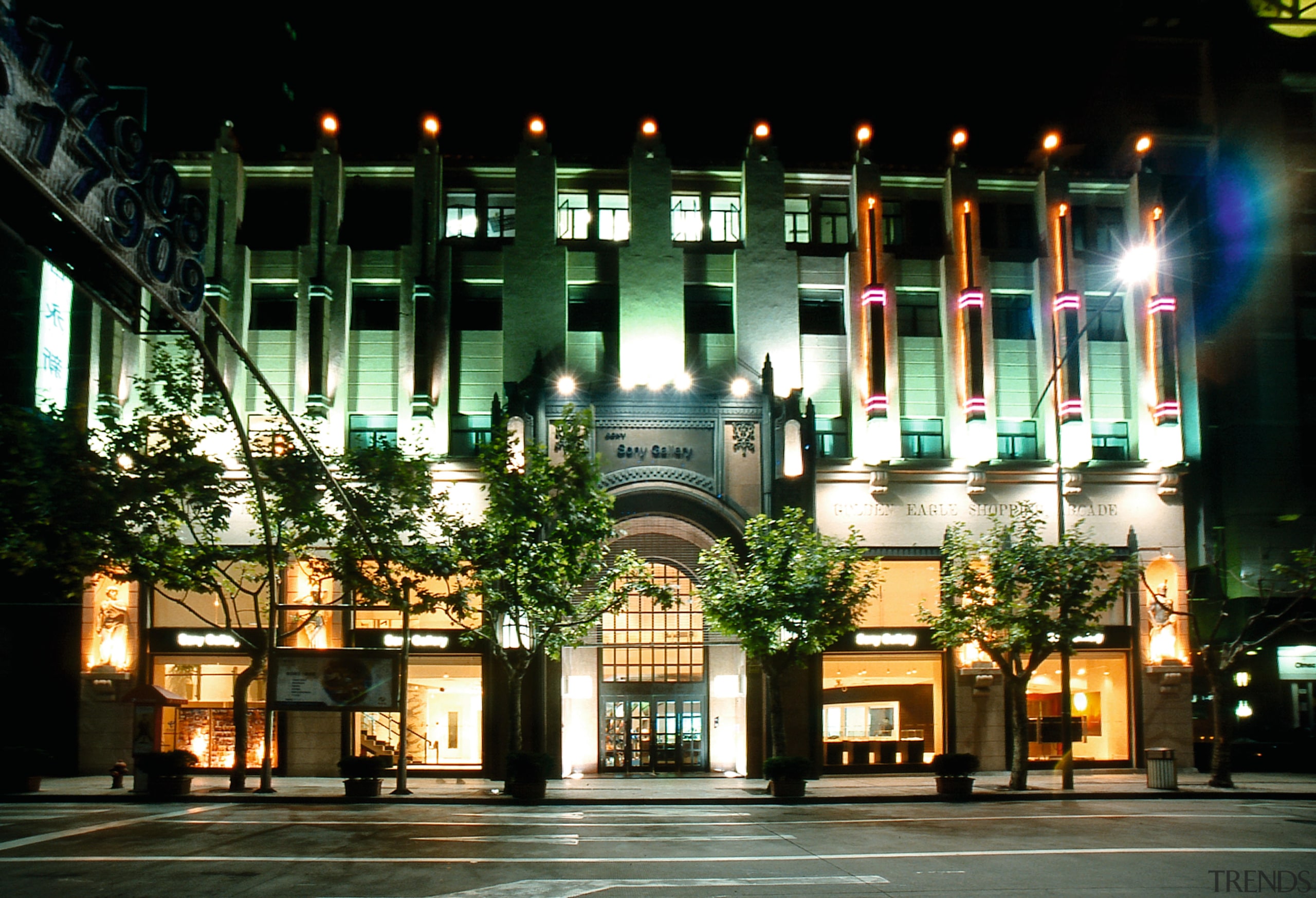 An exterior view of the large three storey architecture, building, city, condominium, downtown, facade, hotel, landmark, lighting, metropolis, metropolitan area, mixed use, night, black