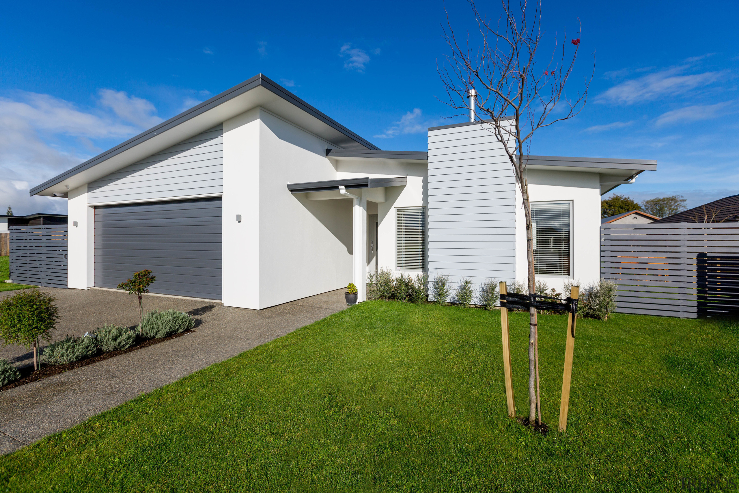 Two new homes by Fowler Homes Manawatu take building, cottage, elevation, estate, facade, grass, home, house, property, real estate, residential area, siding, sky, suburb, yard, brown