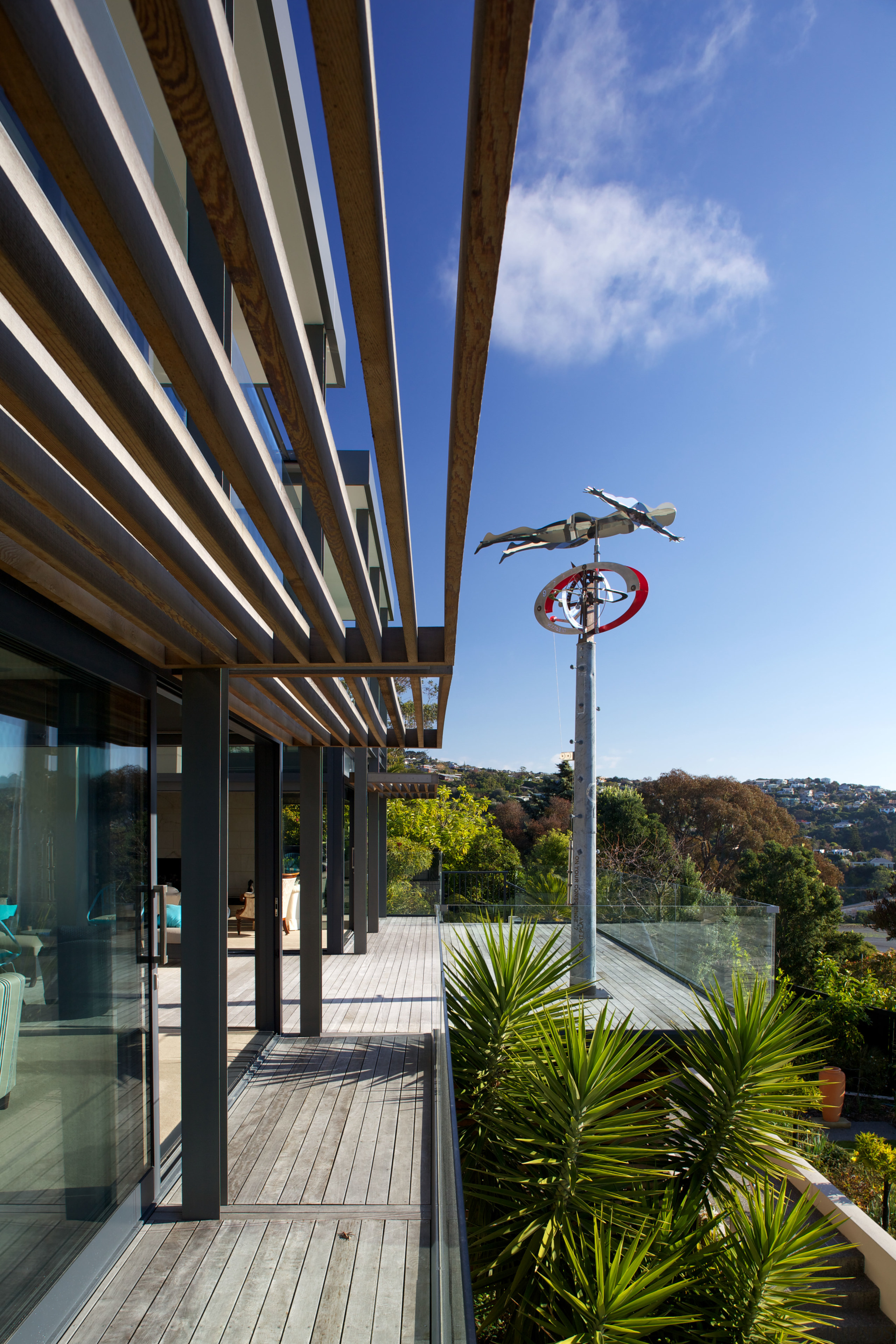 A sculpture by Graham Bennett faces the sea architecture, building, home, house, outdoor structure, real estate, residential area, roof, sky, tree, teal, black