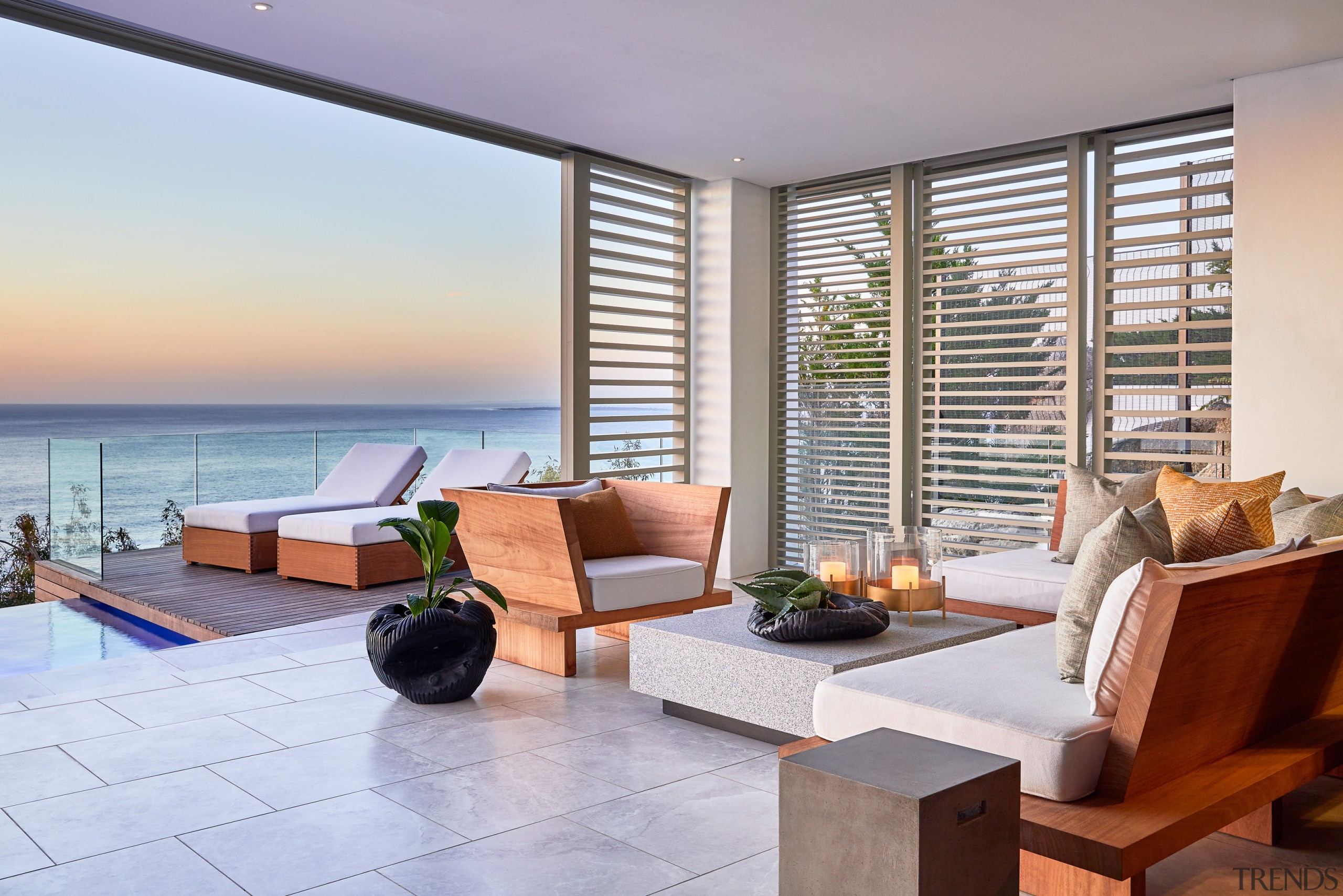 Indoors seamlessly transforms to outdoors in the upmarket apartment, architecture, balcony, building, coffee table, condominium, estate, floor, furniture, hardwood, home, house, interior design, living room, ocean, penthouse apartment, property, real estate, resort, room, suite, table, vacation, window, gray