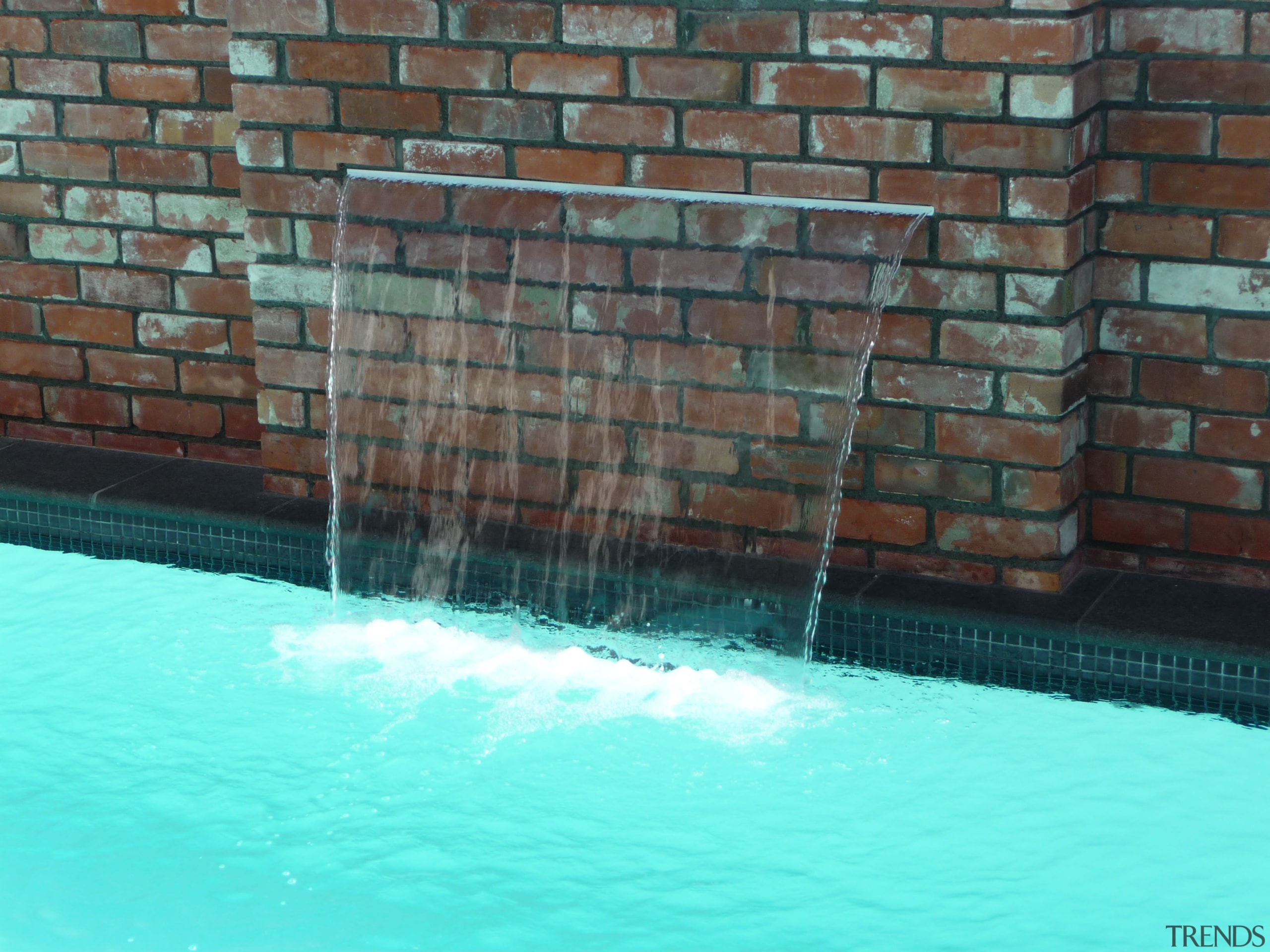 This Mayfair pool includes a 1200mm-wide water feature. brick, swimming pool, wall, water, water feature, teal, black