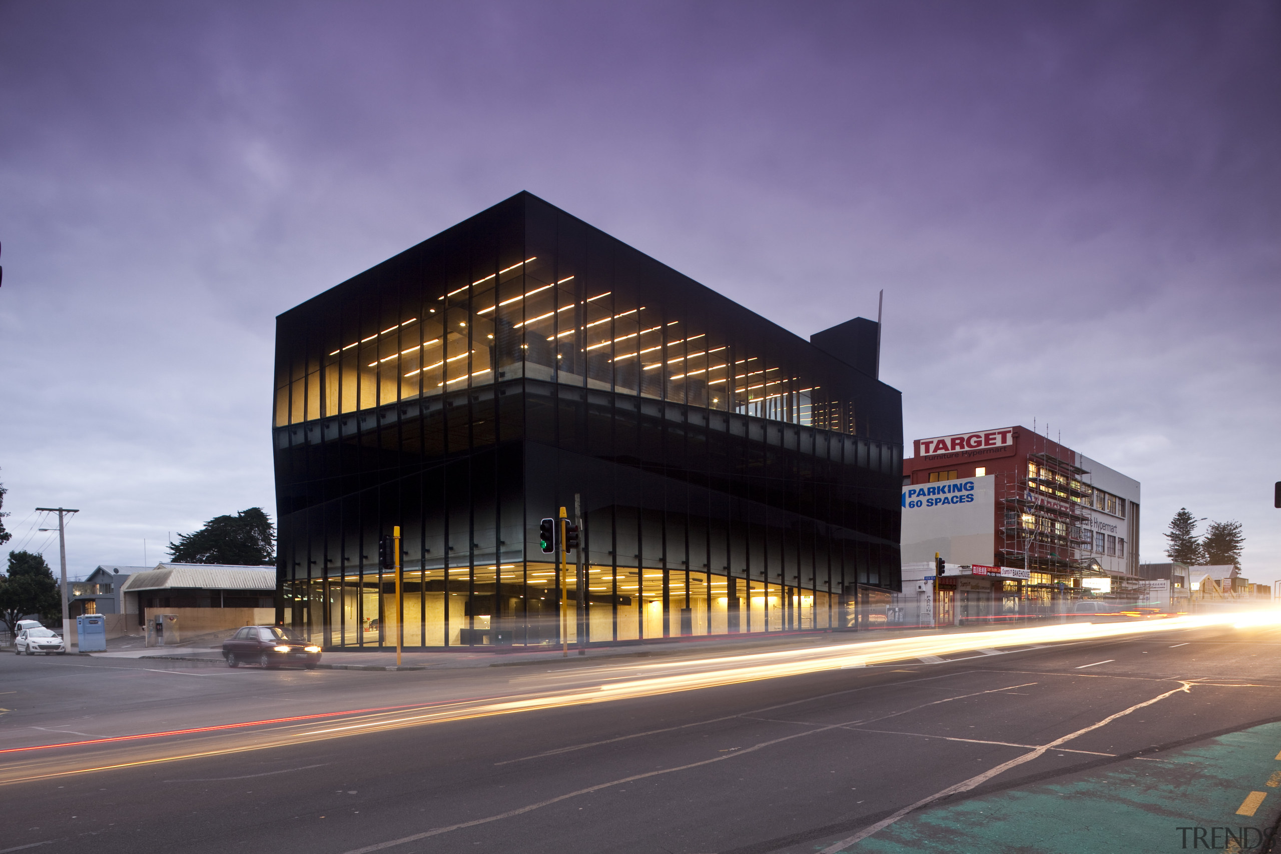 View of the Anvil Building, with angled custom architecture, building, city, commercial building, corporate headquarters, downtown, evening, facade, headquarters, infrastructure, metropolis, metropolitan area, mixed use, night, real estate, reflection, residential area, sky, structure, purple