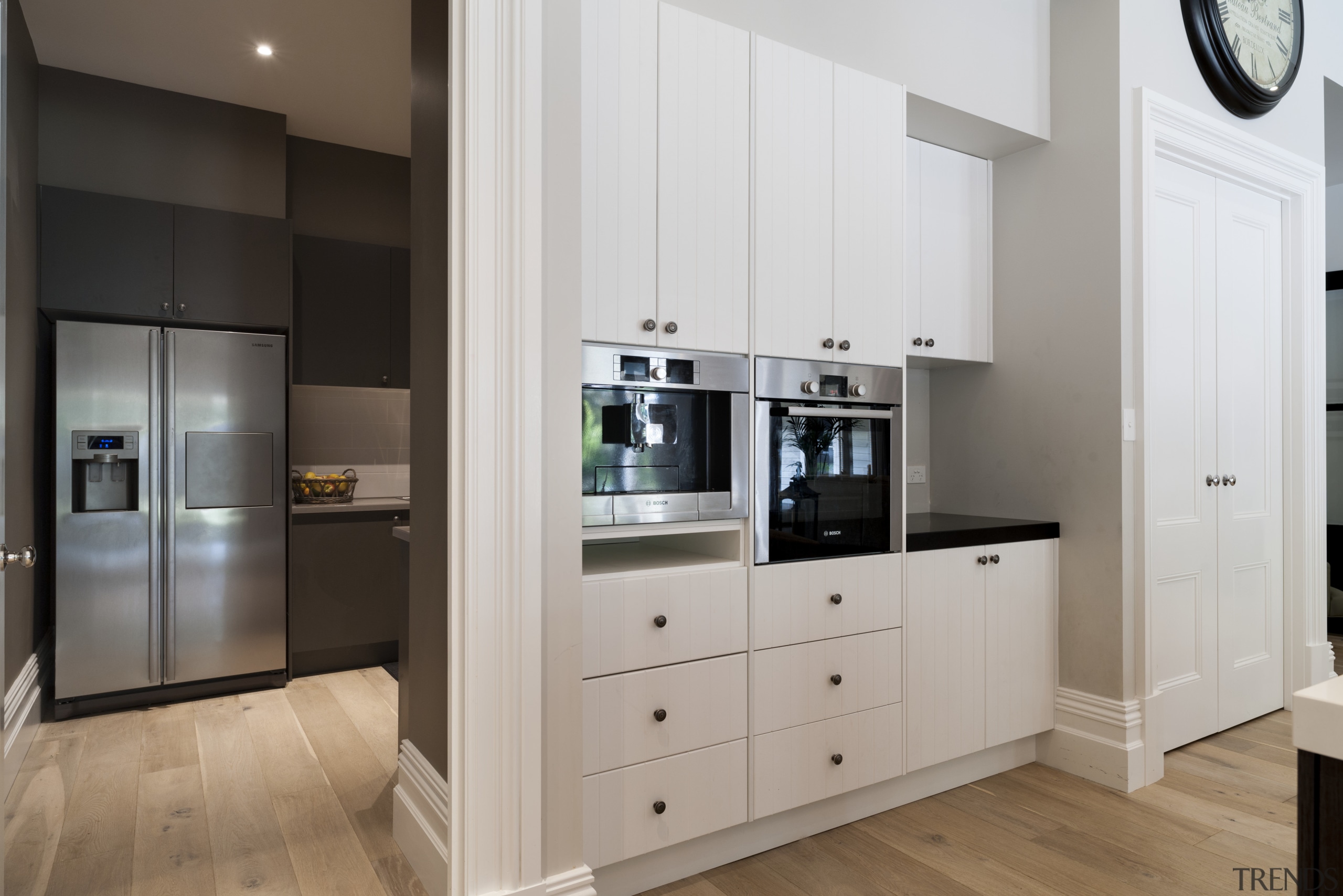 The L-shaped butlers pantry is contemporary, with modern cabinetry, countertop, floor, home appliance, interior design, kitchen, room, gray