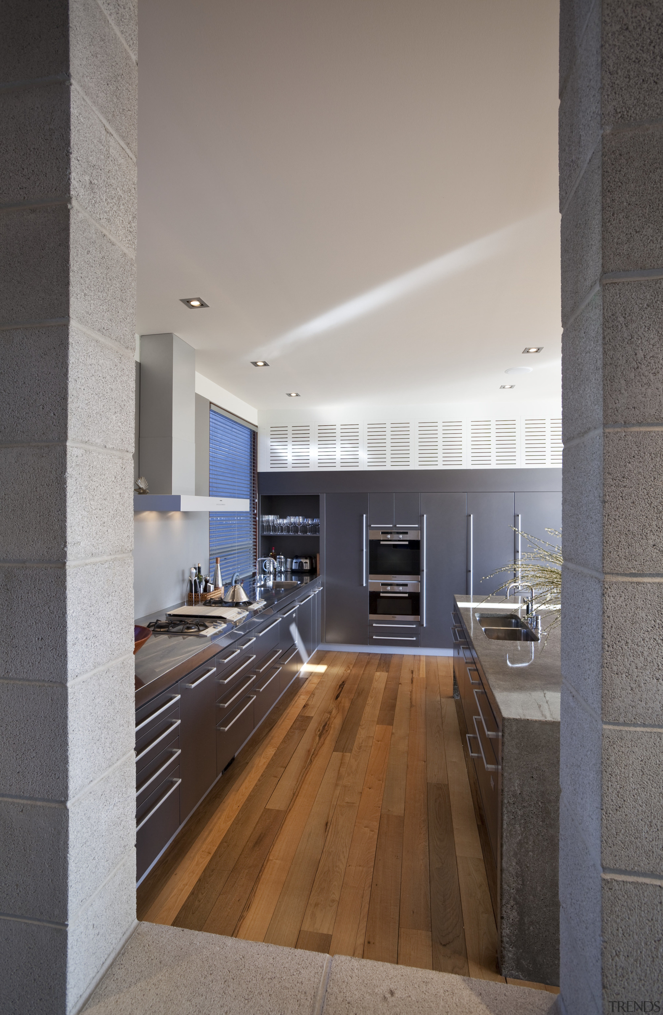 View of kitchen which features concrete benchtops, painted architecture, countertop, daylighting, floor, flooring, house, interior design, kitchen, loft, wood flooring, gray