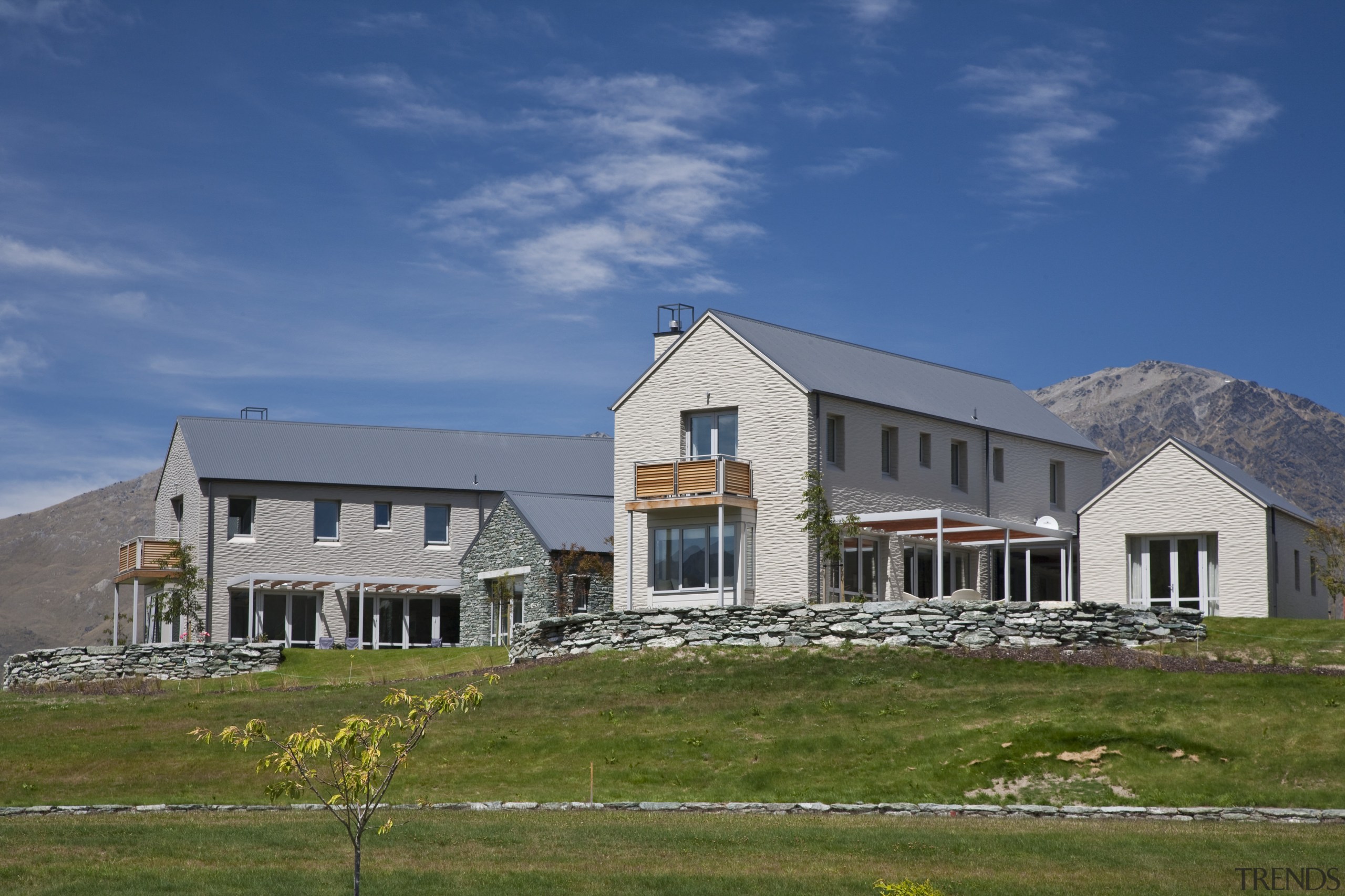 Exterior view of a home which features a cloud, cottage, elevation, estate, facade, farmhouse, home, house, landscape, mountain, property, real estate, residential area, roof, rural area, siding, sky, blue, brown