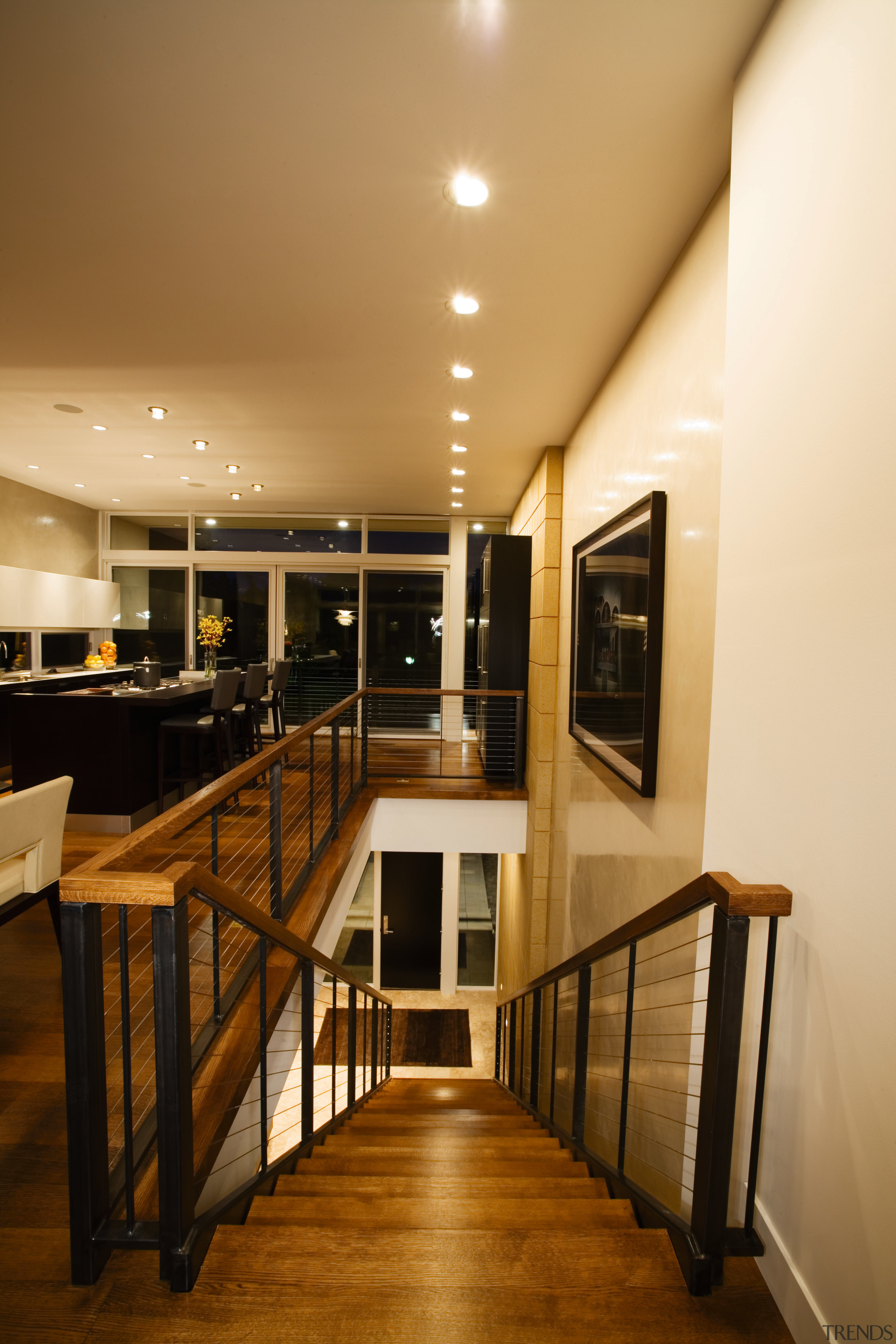 A view of a home designed by Streeter ceiling, floor, flooring, furniture, handrail, interior design, lighting, room, table, wood, orange, brown