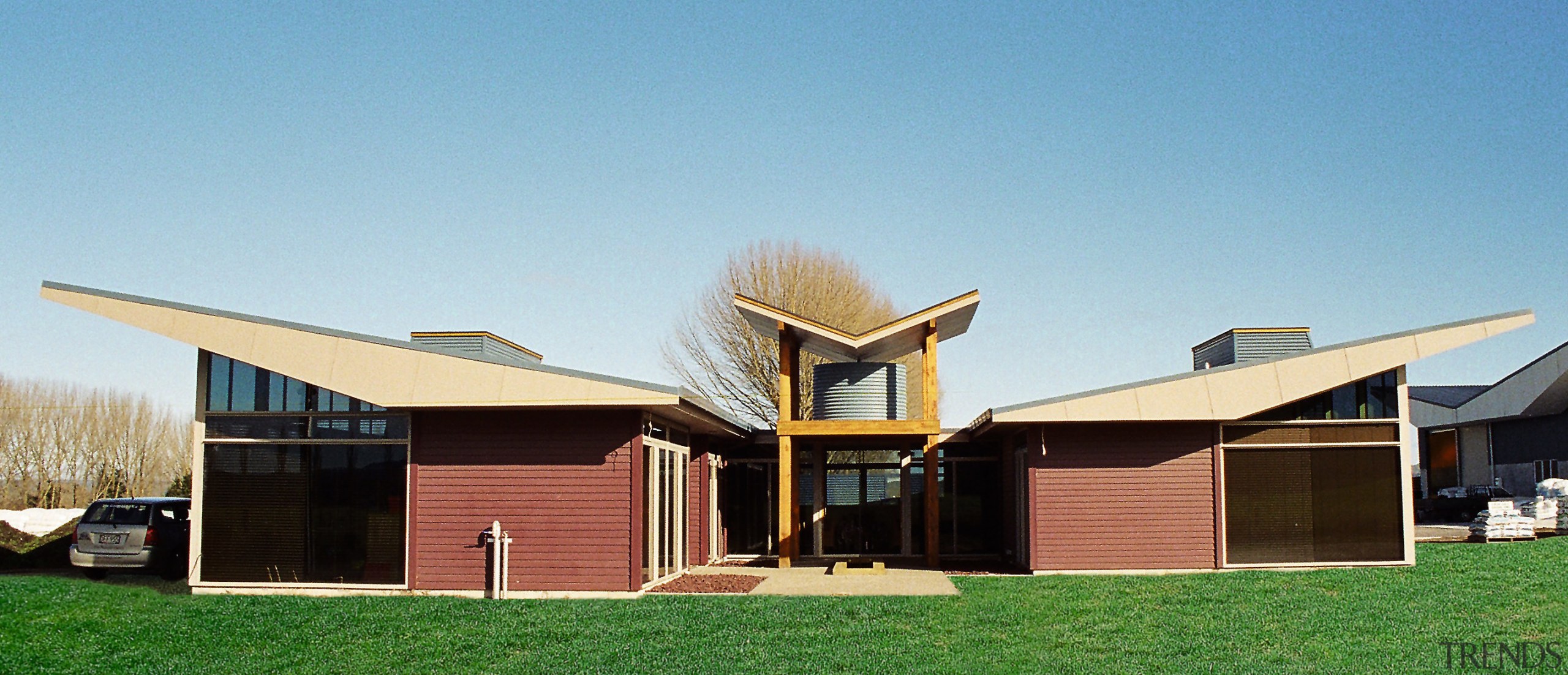 Exterior view of this building, low sloped pitched architecture, cottage, elevation, facade, farmhouse, home, house, property, real estate, residential area, roof, siding, teal