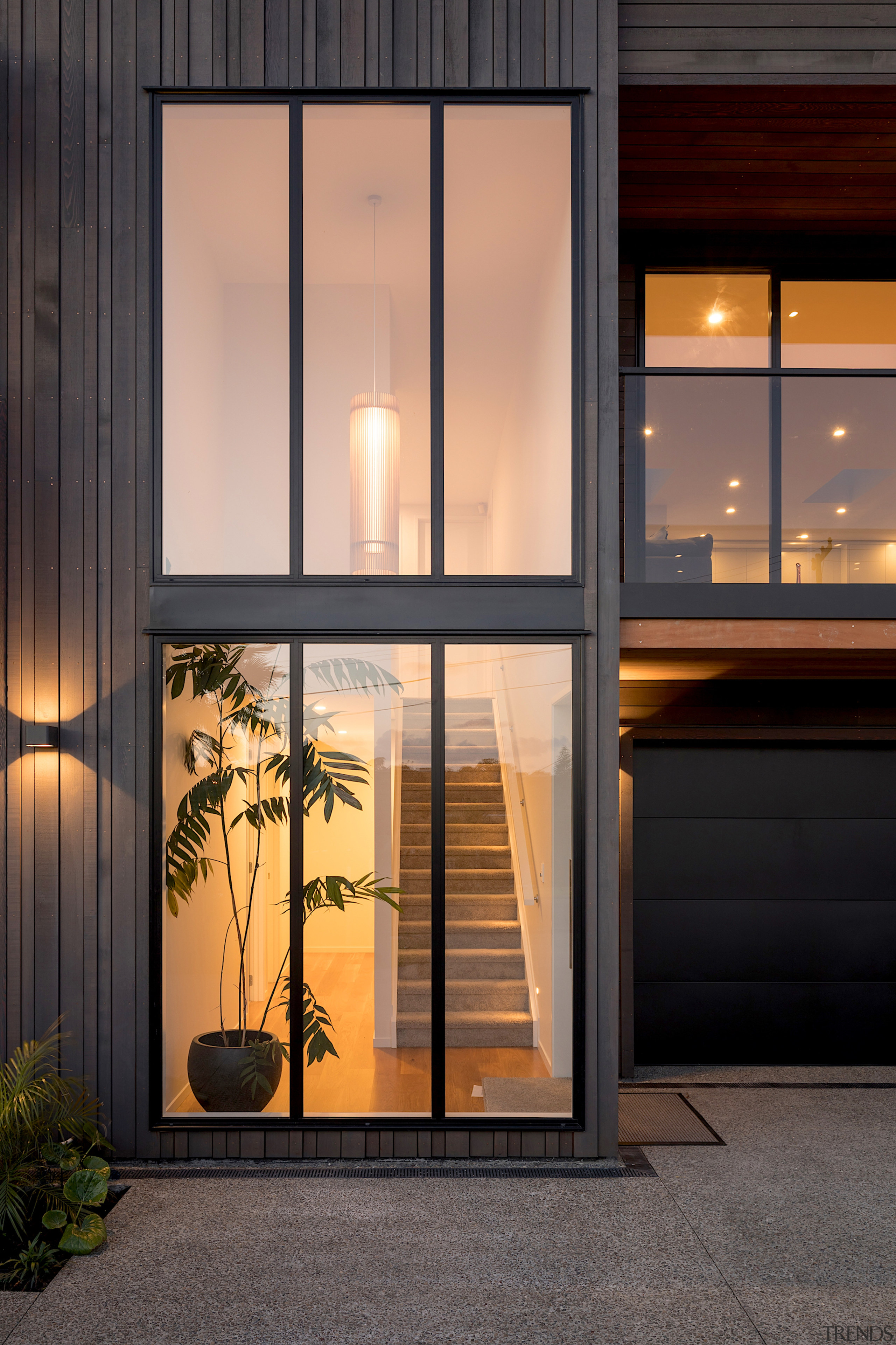 The focal point of this renovated home's front architecture, auto part, automotive exterior, building, door, facade, furniture, glass, home, house, interior design, material property, real estate, room, tree, vehicle door, window, black, orange