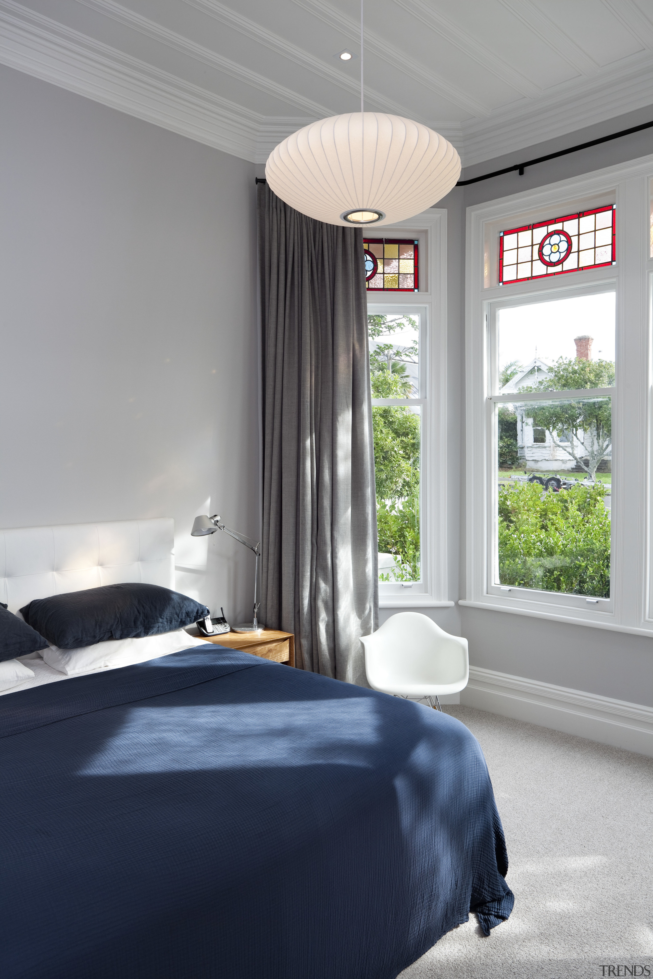 Bedroom with blue bedspread and hanging light. architecture, bed frame, bedroom, ceiling, home, house, interior design, real estate, room, wall, window, gray