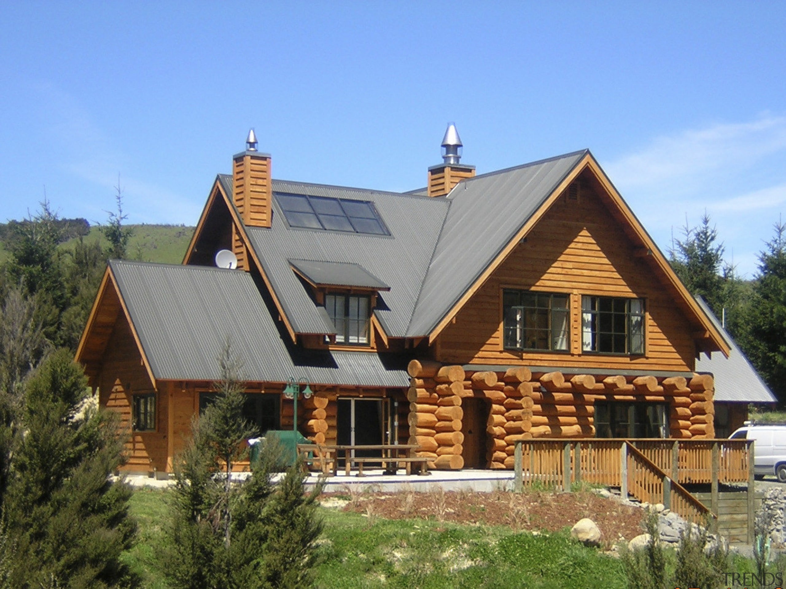 This large home efficiently uses solar energy thanks cottage, elevation, estate, facade, farmhouse, home, house, hut, log cabin, property, real estate, roof, siding, window, wood, teal, brown