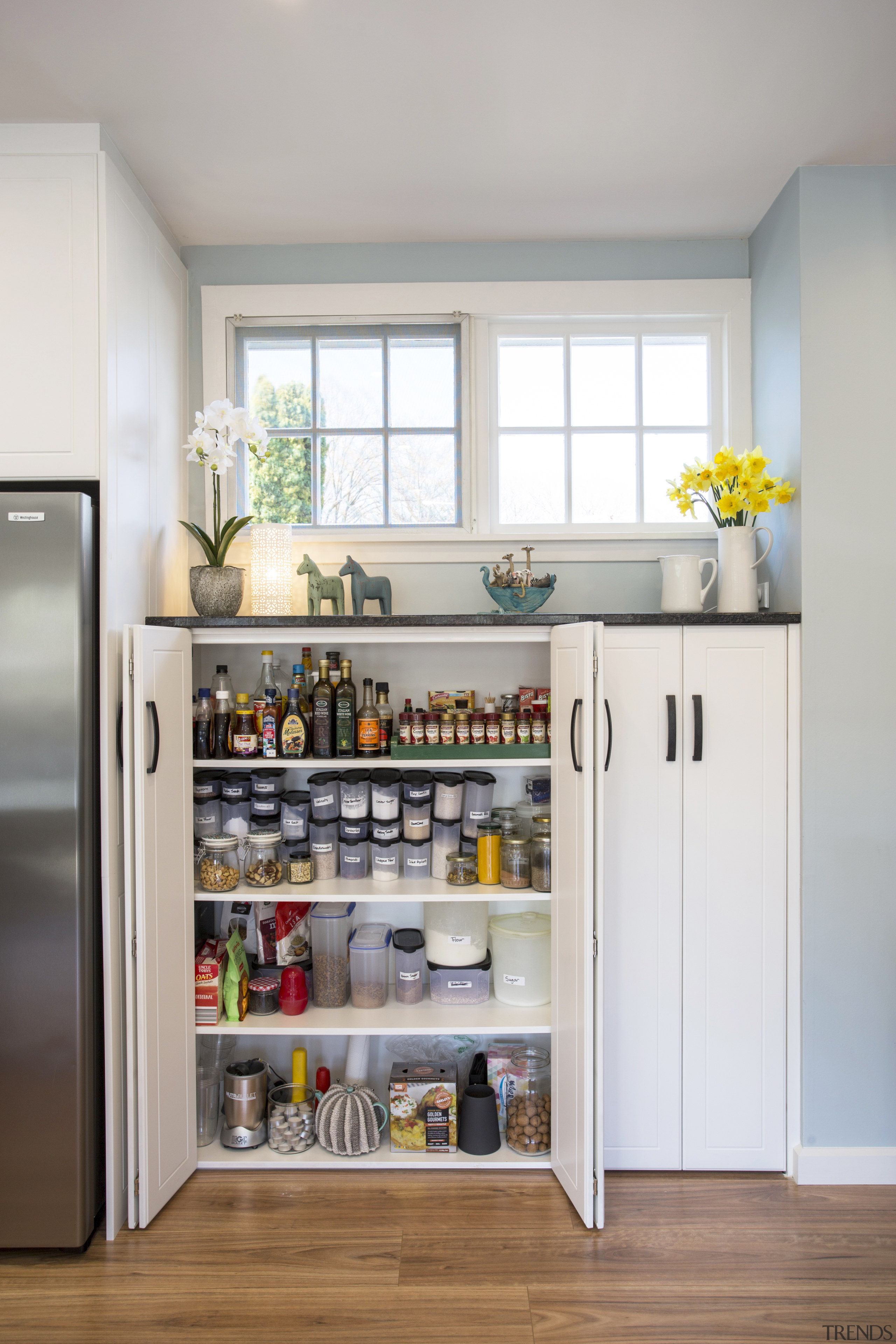 The cabinets under the window appear as three cabinetry, countertop, home appliance, interior design, kitchen, refrigerator, room, shelf, shelving, gray