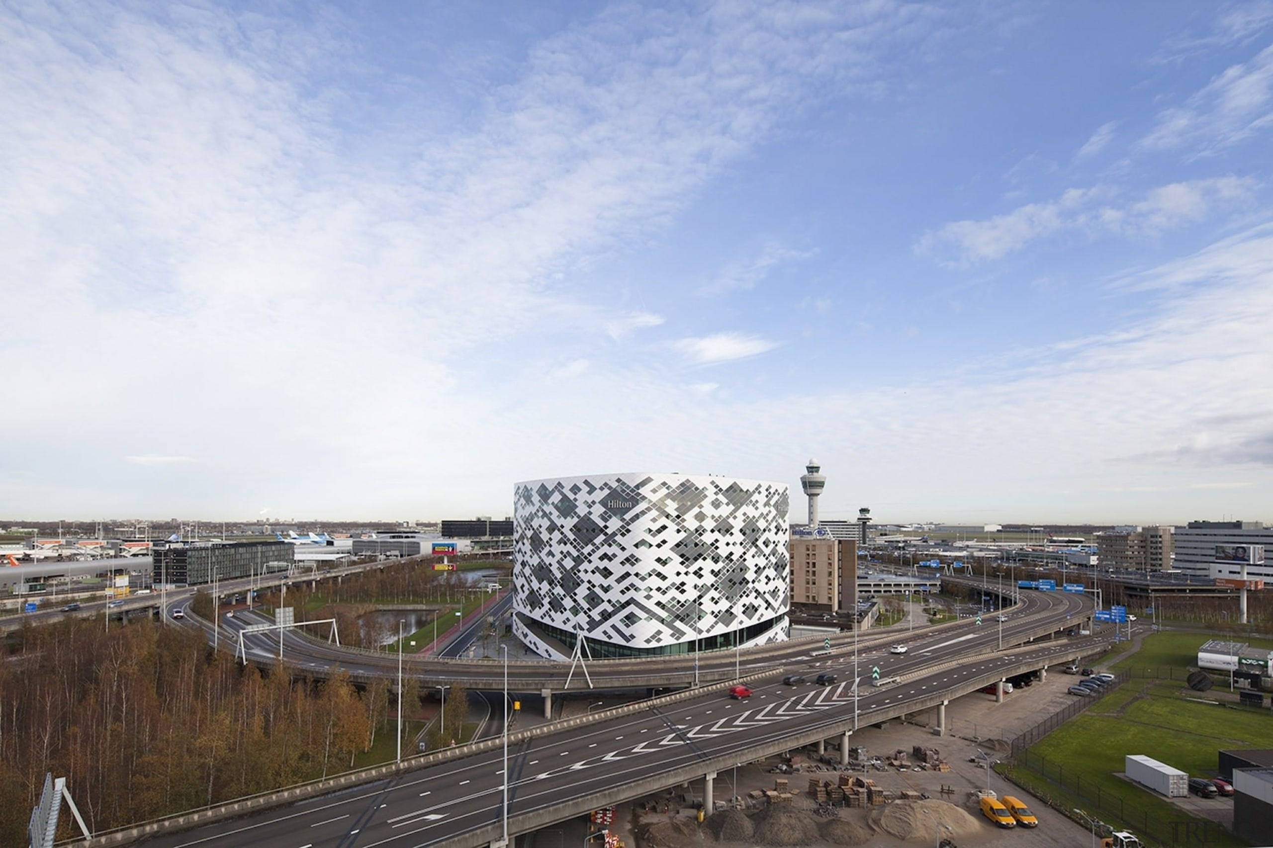 The main airport access roads ring the building building, city, cloud, daytime, fixed link, horizon, metropolitan area, road, sky, white