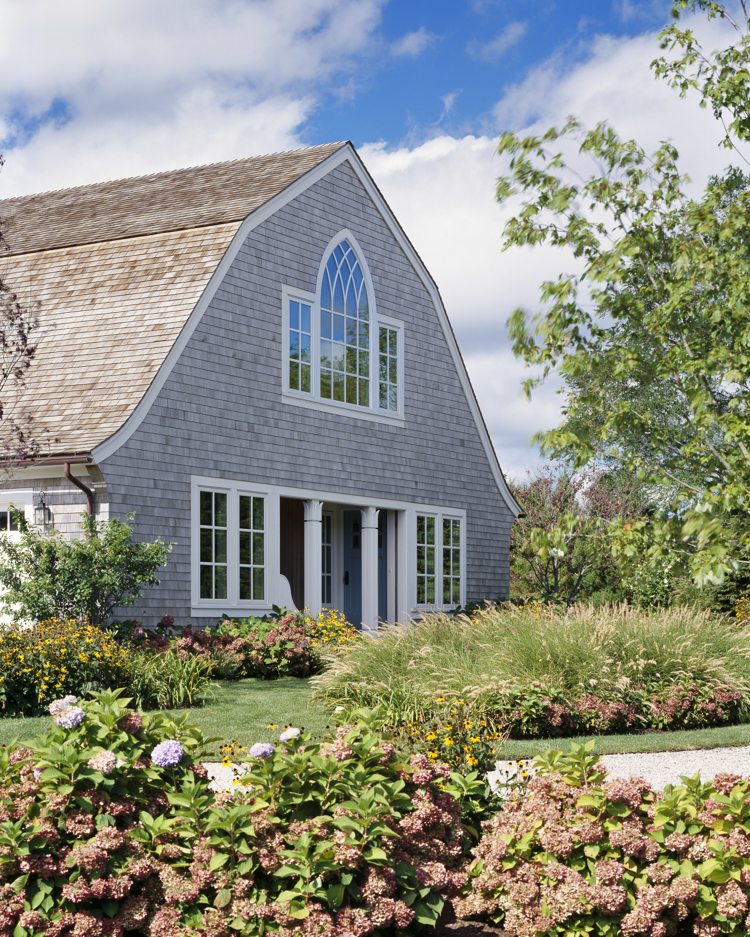 A porch and columns signal the formal entrance cottage, estate, farmhouse, garden, home, house, landscaping, plant, property, real estate, sky, yard, white