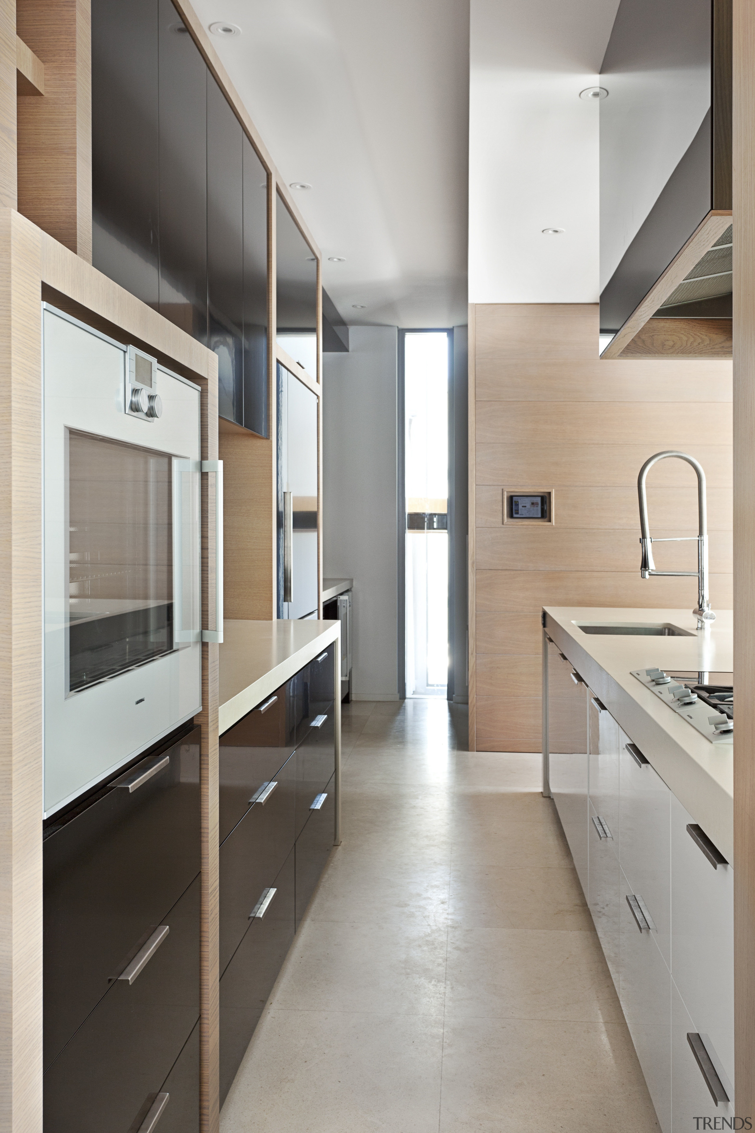 This kitchen features multiple countertops and cooking zones. architecture, cabinetry, countertop, floor, interior design, kitchen, room, gray