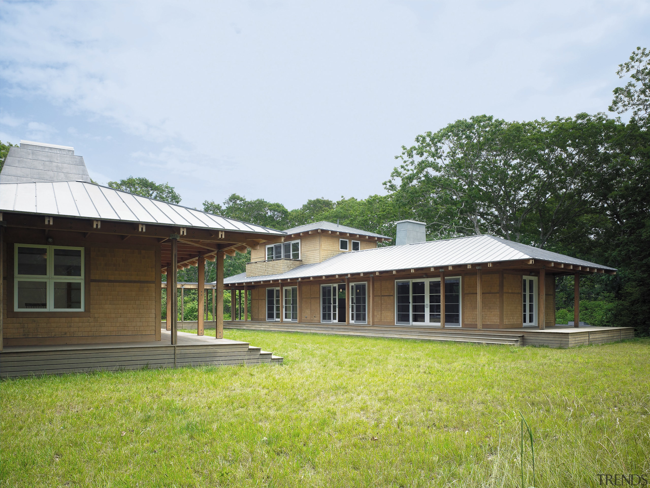 exterior veiw of this vaction home nestle in cottage, estate, facade, farmhouse, grass, home, house, land lot, landscape, property, real estate, roof, white