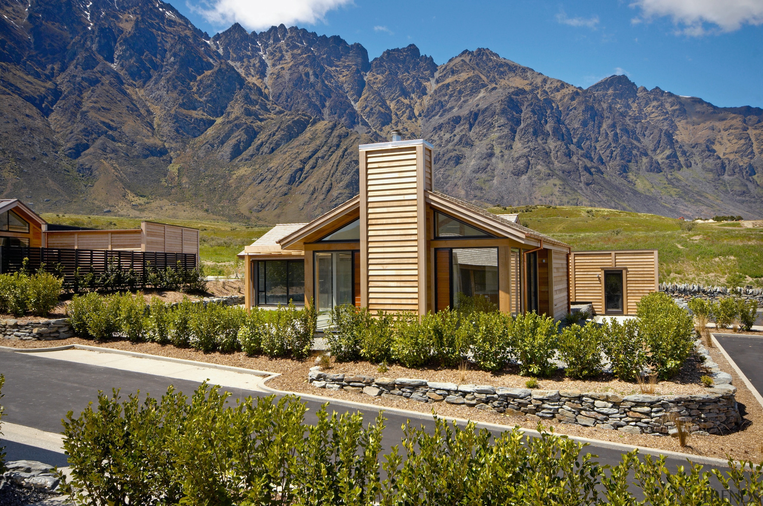 A view of a home by Fletcher Living. architecture, cottage, elevation, estate, home, house, hut, landscape, mountain, mountain range, property, real estate, residential area, sky, brown