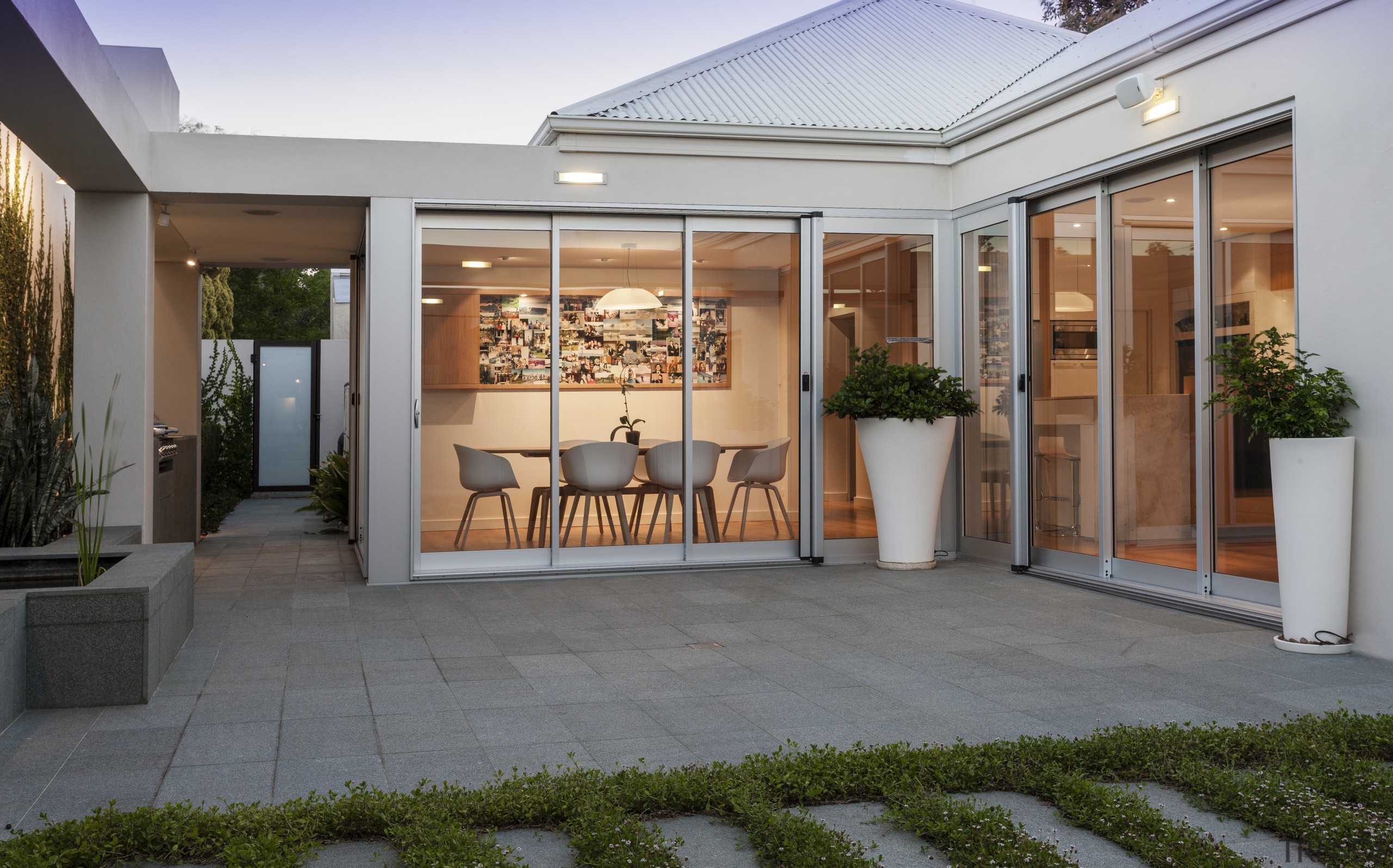 A continuity of materials helps to unify the courtyard, door, estate, facade, home, interior design, patio, property, real estate, window, gray