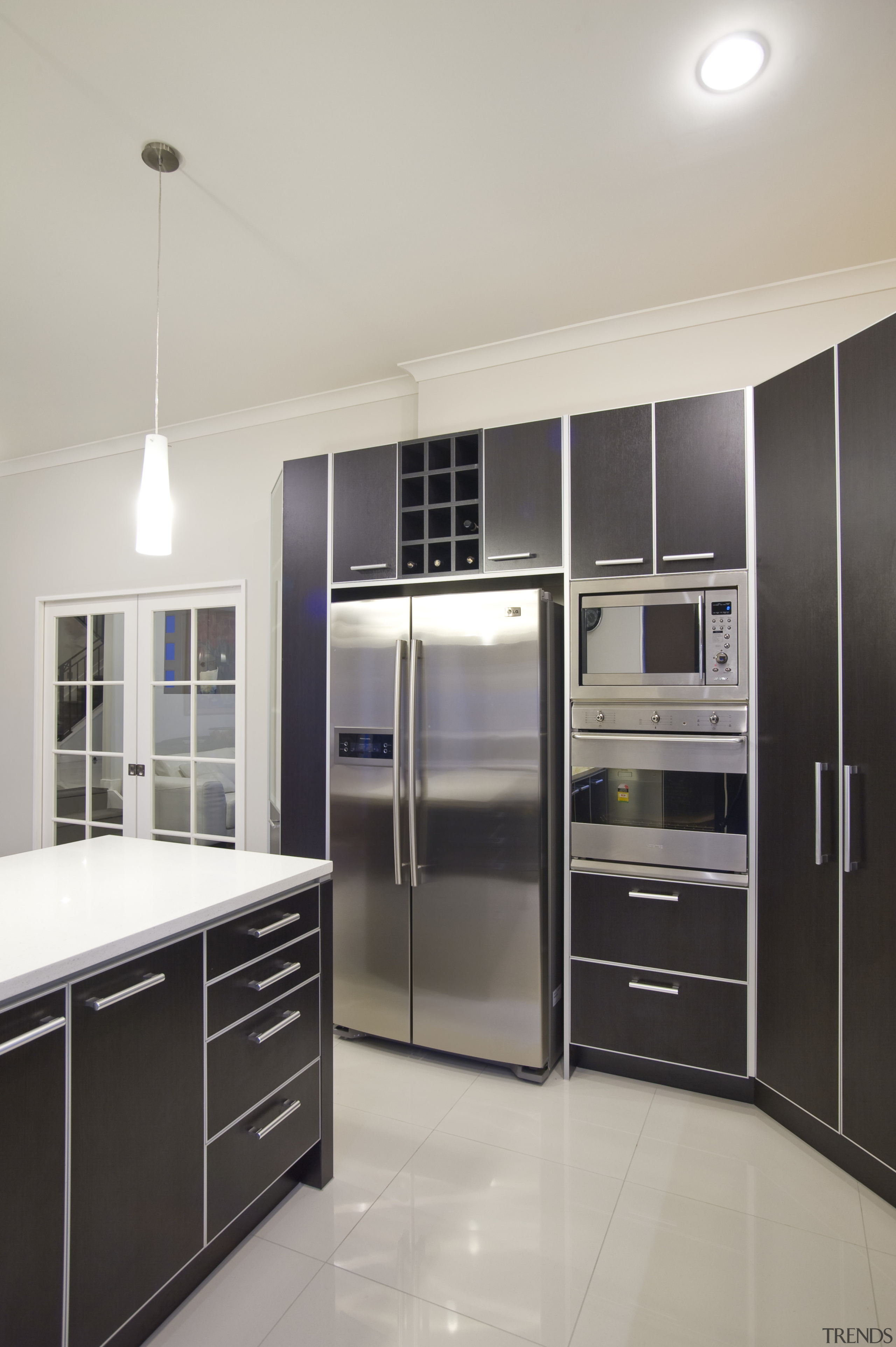 View of a kitchen which features dark stained cabinetry, countertop, home appliance, interior design, kitchen, major appliance, refrigerator, gray
