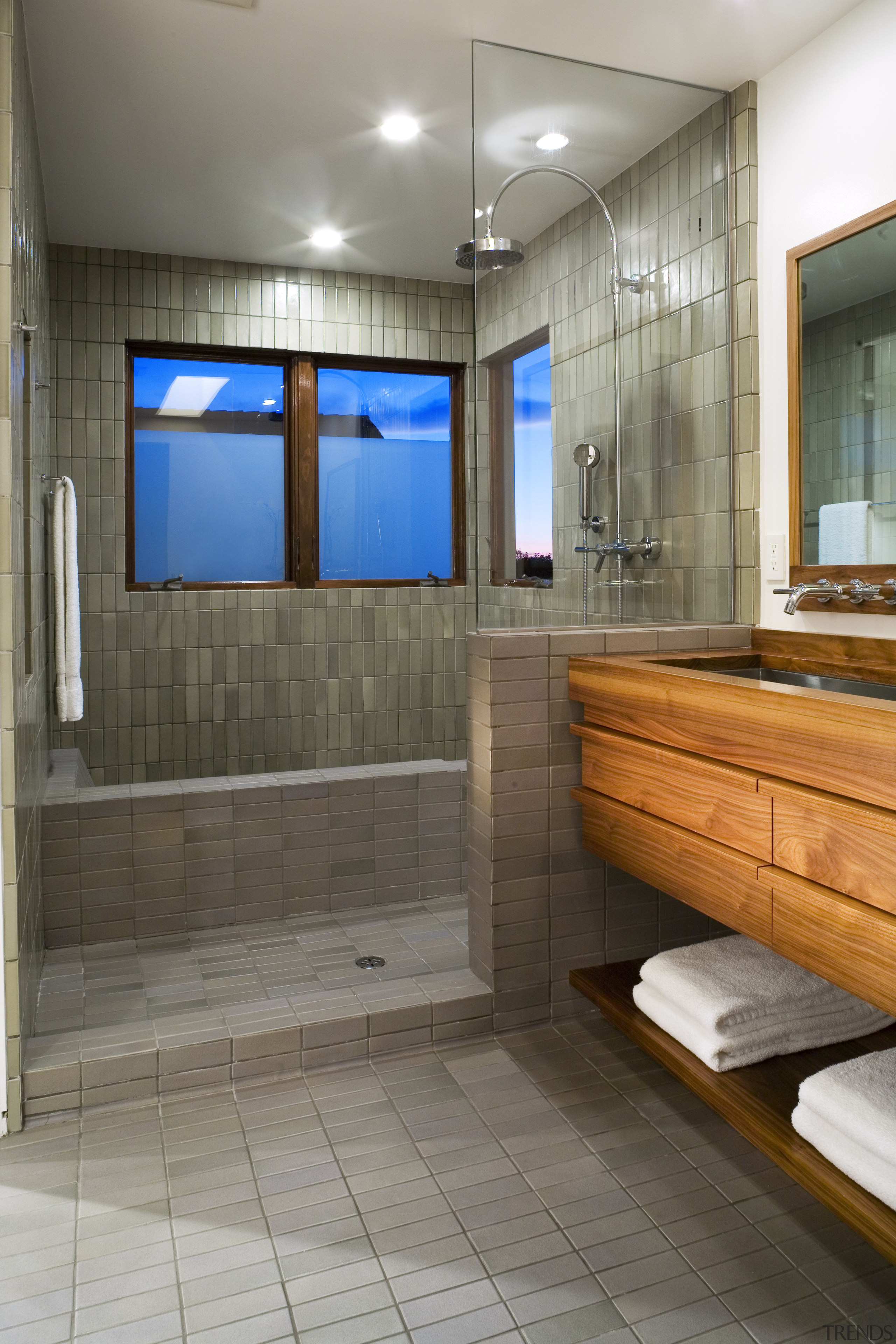 The wet area of the bathroom includes the bathroom, floor, flooring, interior design, lobby, room, tile, gray