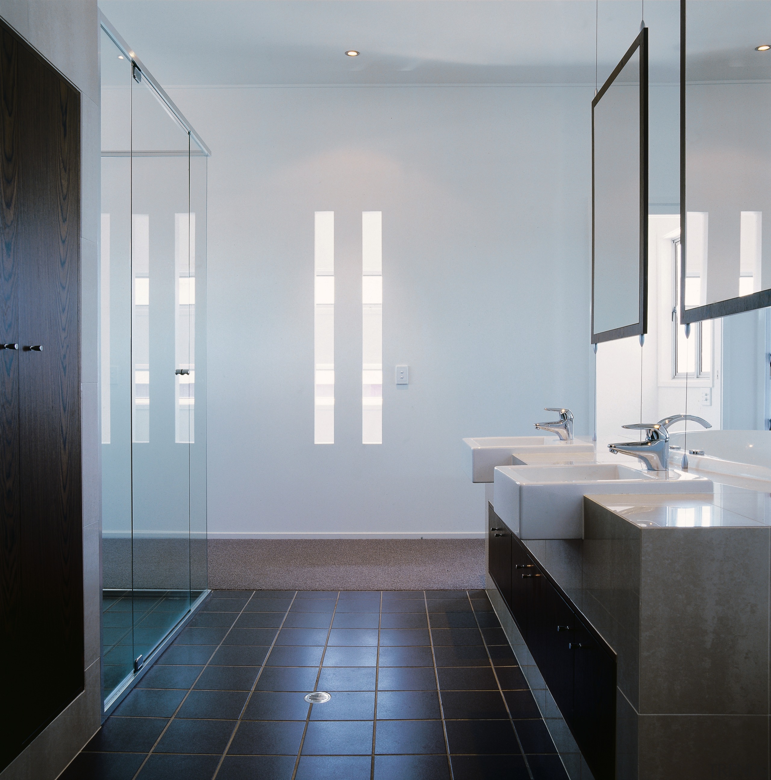 view of the bathroom featuring tiled flooring, glased architecture, bathroom, daylighting, floor, glass, interior design, plumbing fixture, room, sink, tile, gray
