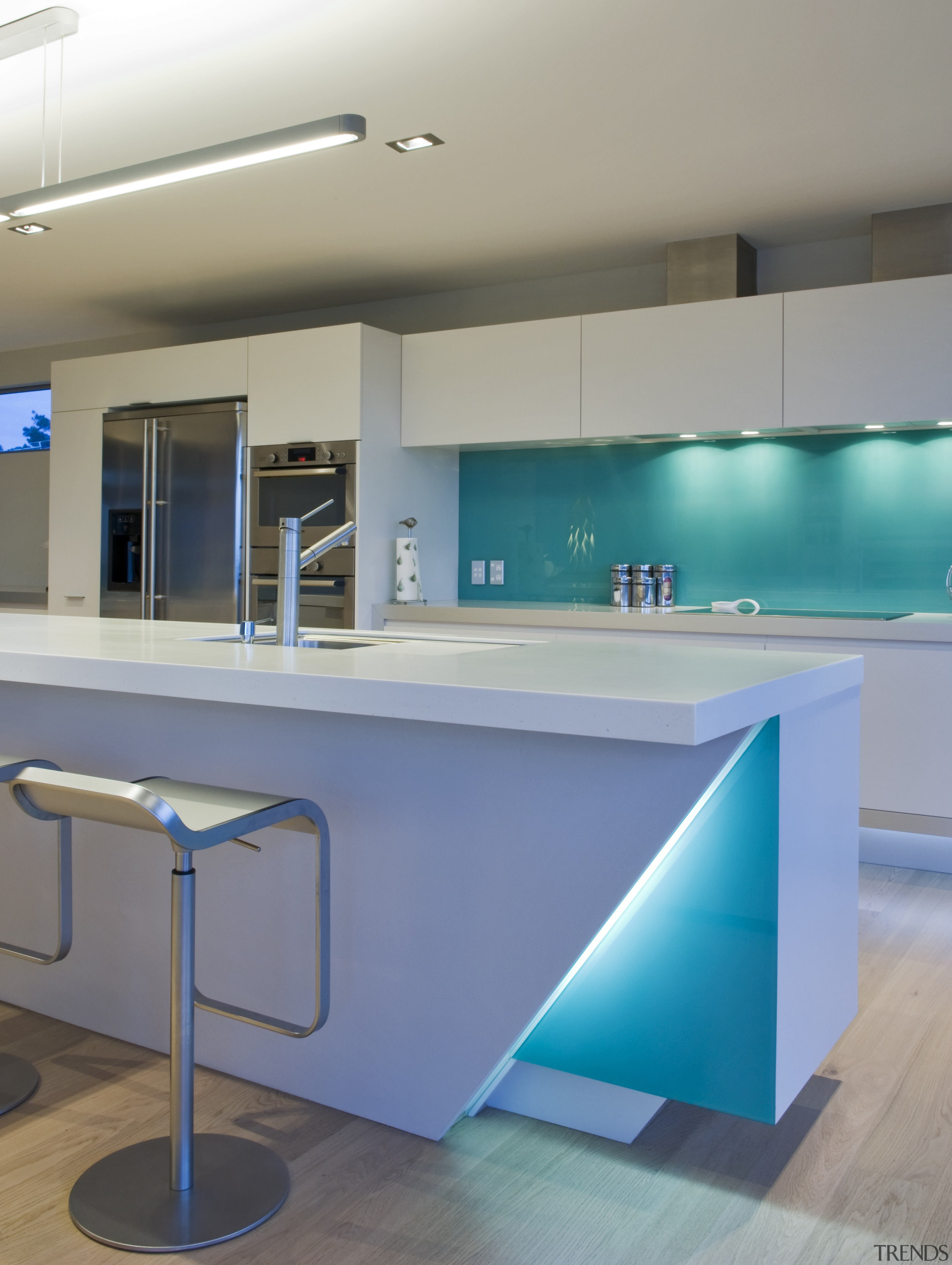 This sleek kitchen in a beach house features countertop, floor, glass, interior design, kitchen, product design, table, gray