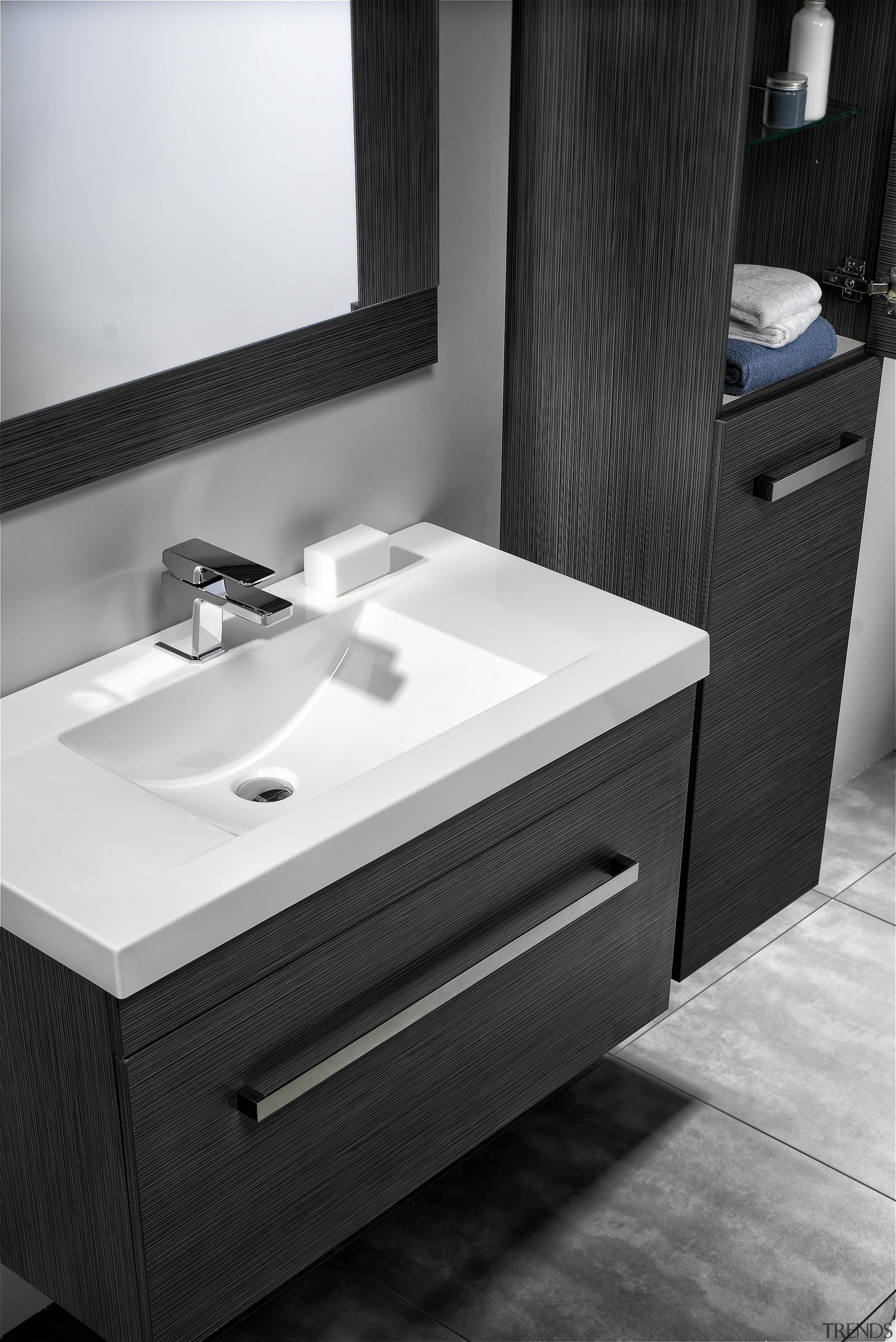 Squared external edges paired with a sweeping basin angle, bathroom, bathroom accessory, bathroom cabinet, bathroom sink, black, drawer, floor, furniture, plumbing fixture, product, product design, sink, tap, black, white