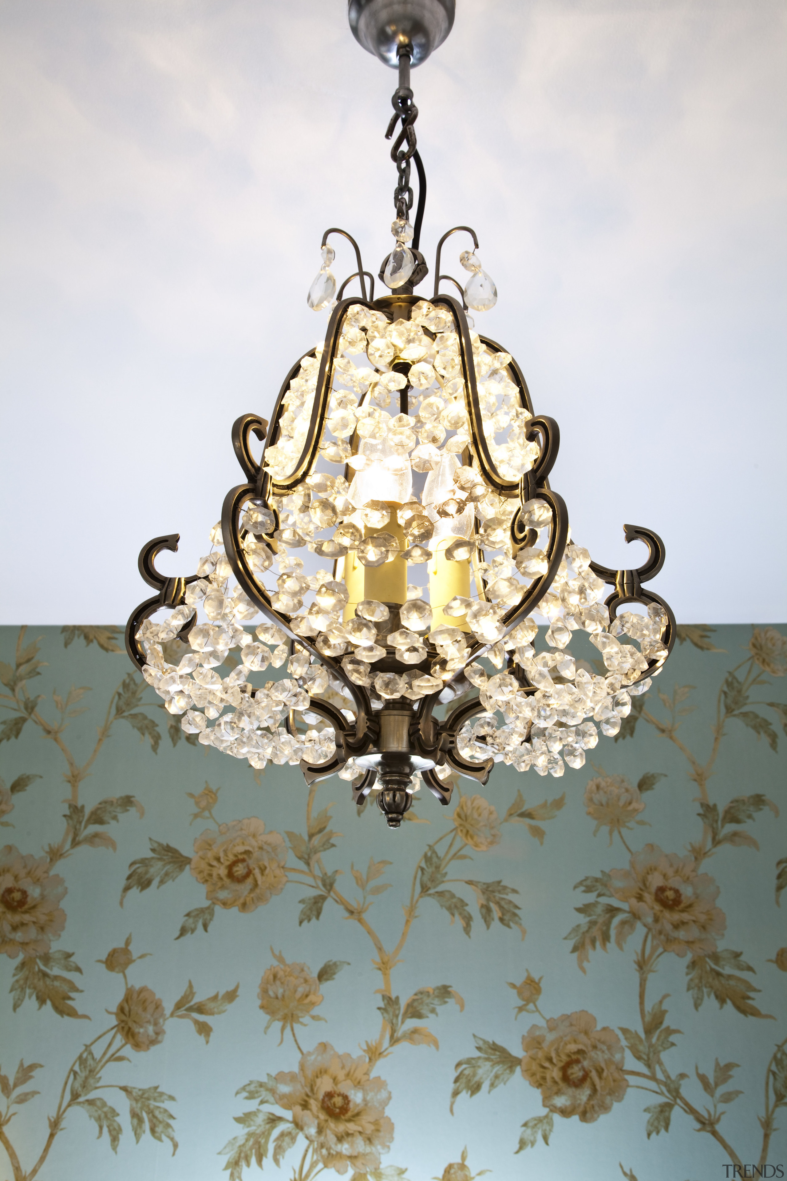 View of bathroom with floral wallpaper and dark-toned chandelier, light fixture, lighting, white, gray