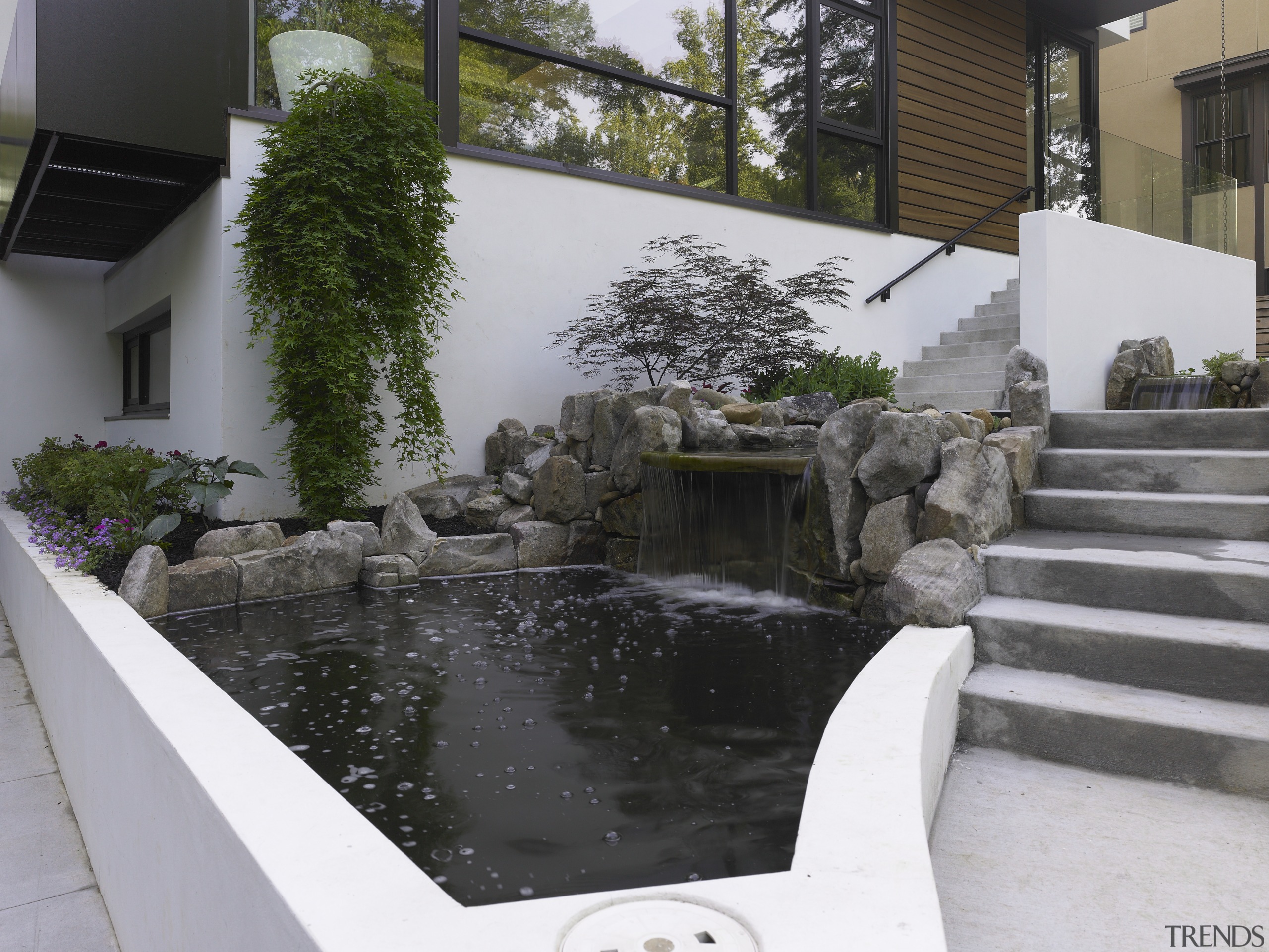 The entrance way to this modern home has backyard, courtyard, pond, swimming pool, water, water feature, yard, black, white