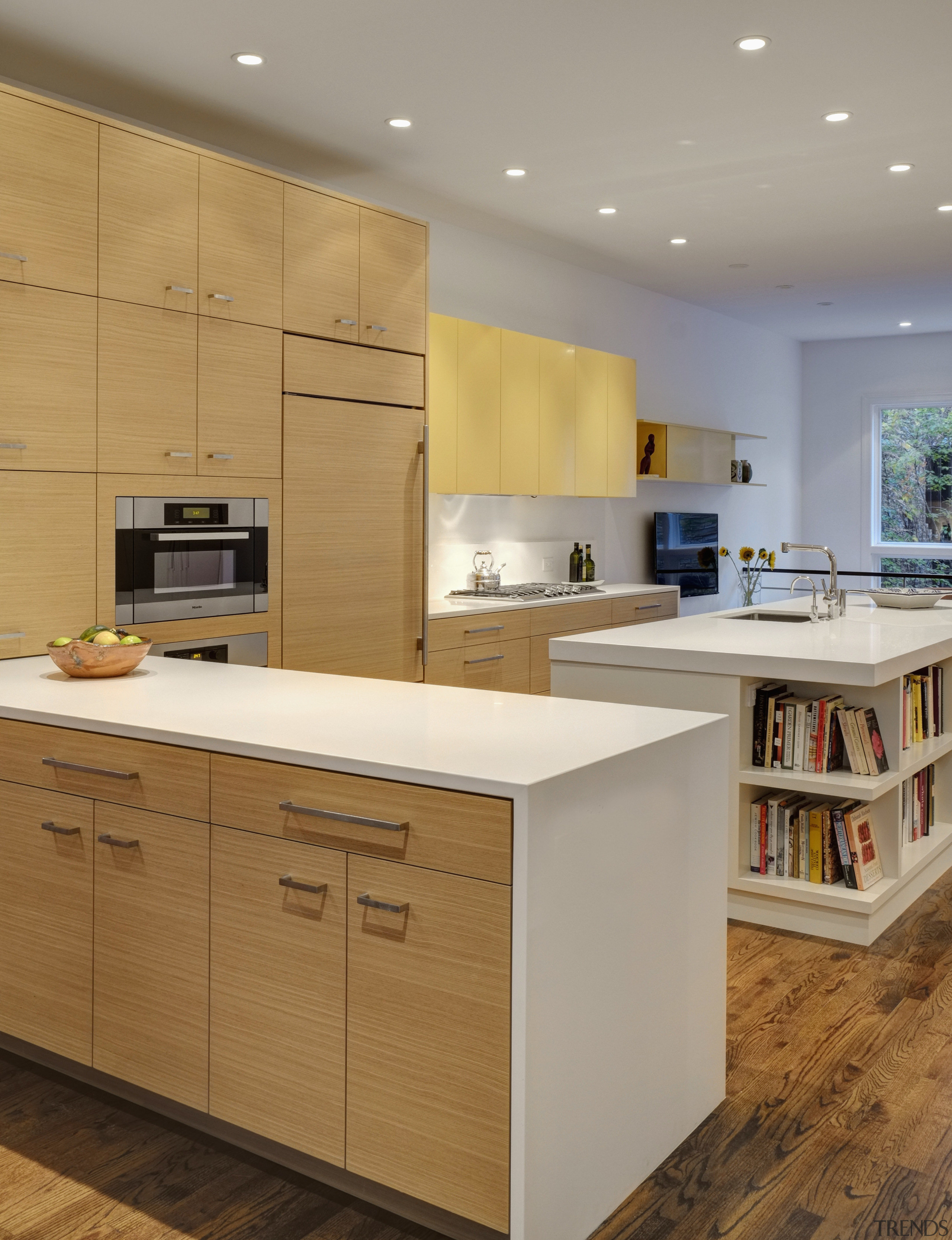 The peninsula in this kitchen serves as a cabinetry, countertop, cuisine classique, floor, hardwood, interior design, kitchen, room, gray, brown