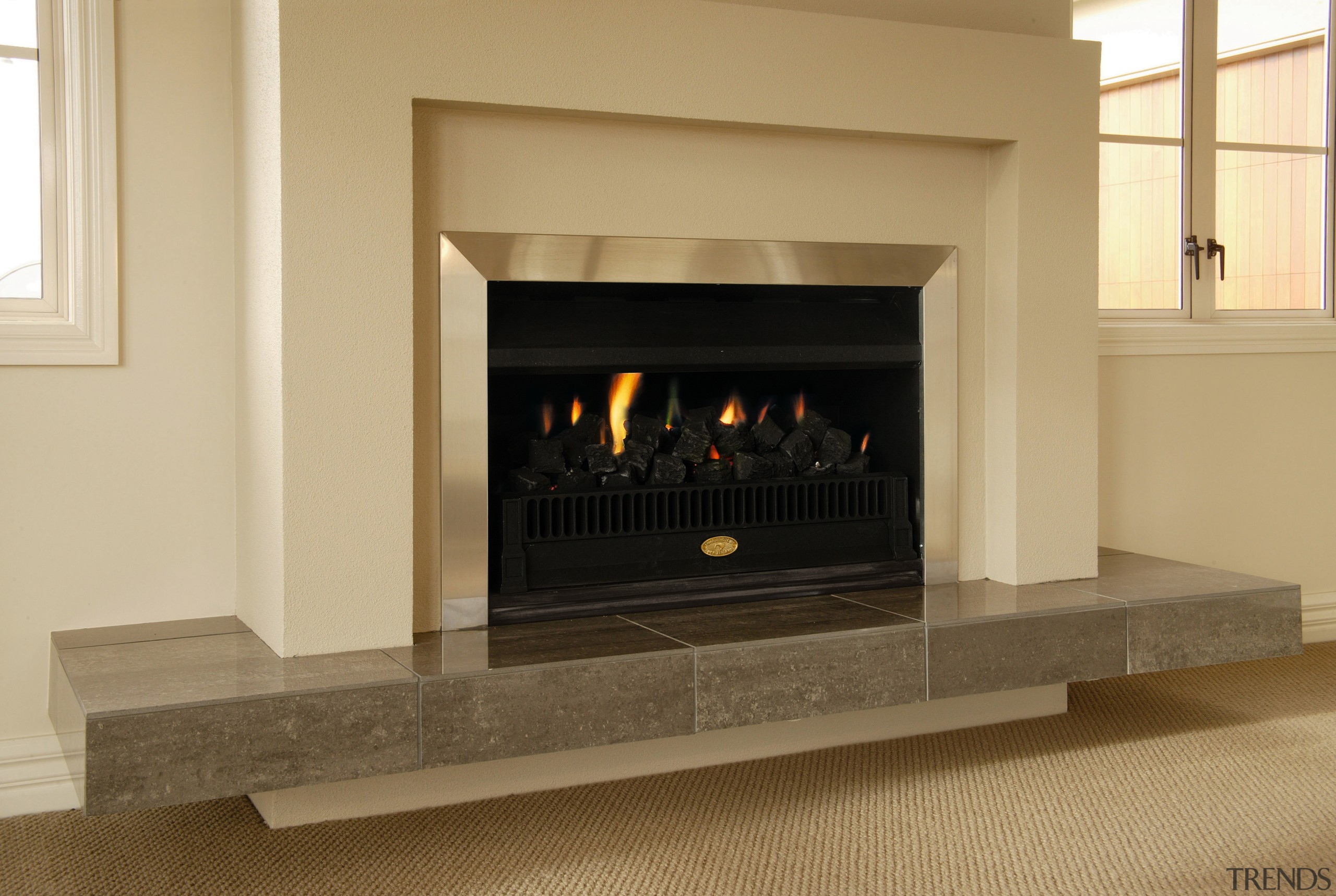 Indoor fireplace with cream and aluminium surround, and fireplace, hearth, heat, wood burning stove, orange, brown