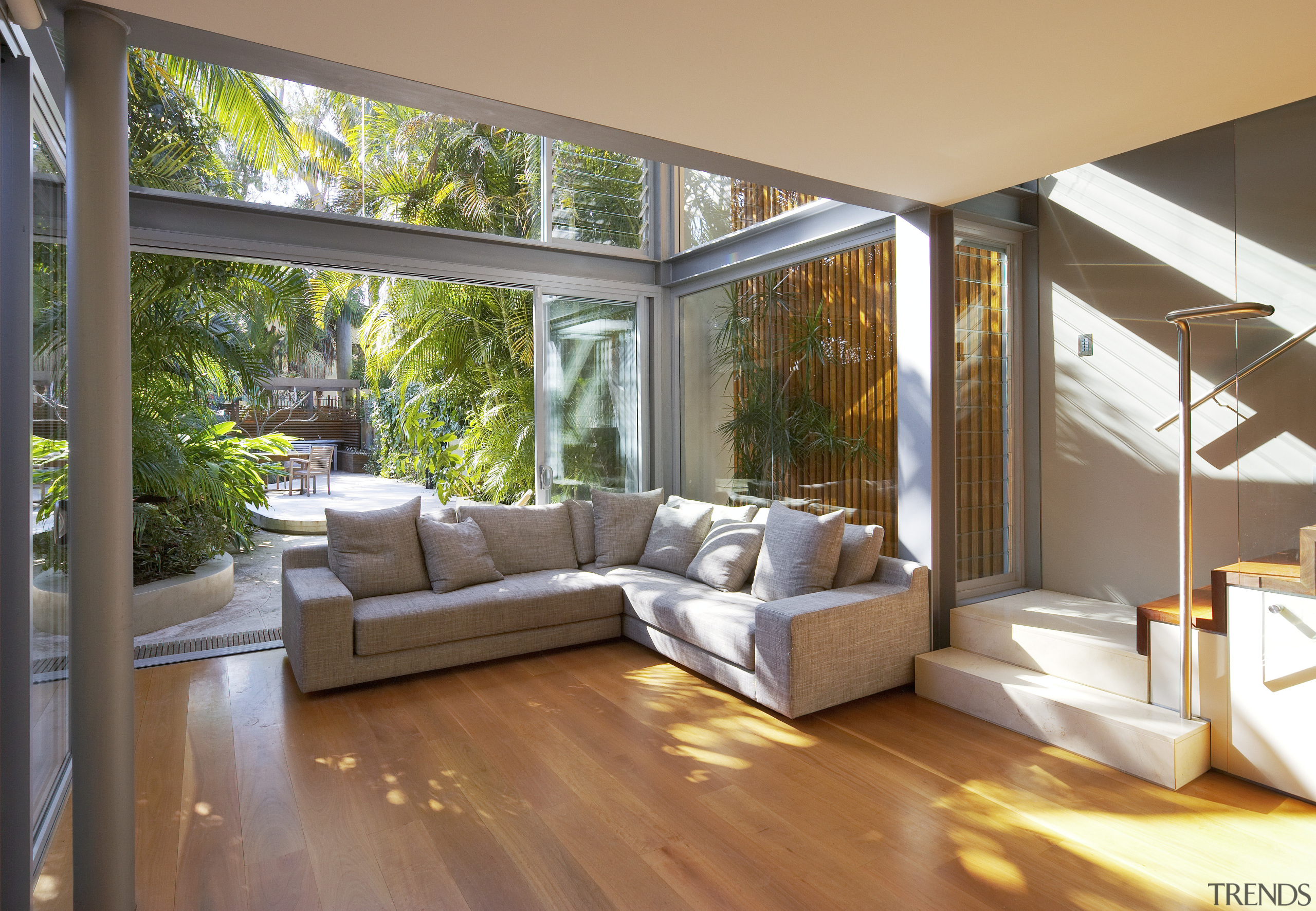 A glazed, three-storey atrium fills this home with architecture, ceiling, daylighting, estate, floor, hardwood, home, house, interior design, living room, property, real estate, window, wood, wood flooring, brown