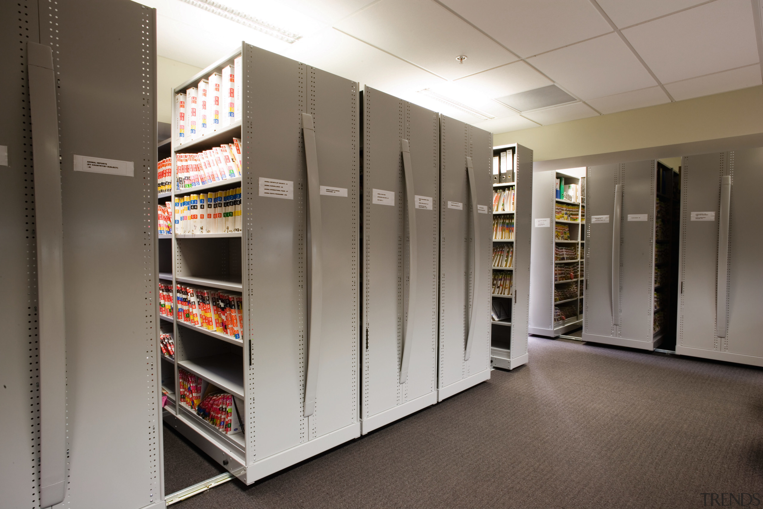 A view of some shelving storage systems. - floor, flooring, institution, shelf, shelving, gray