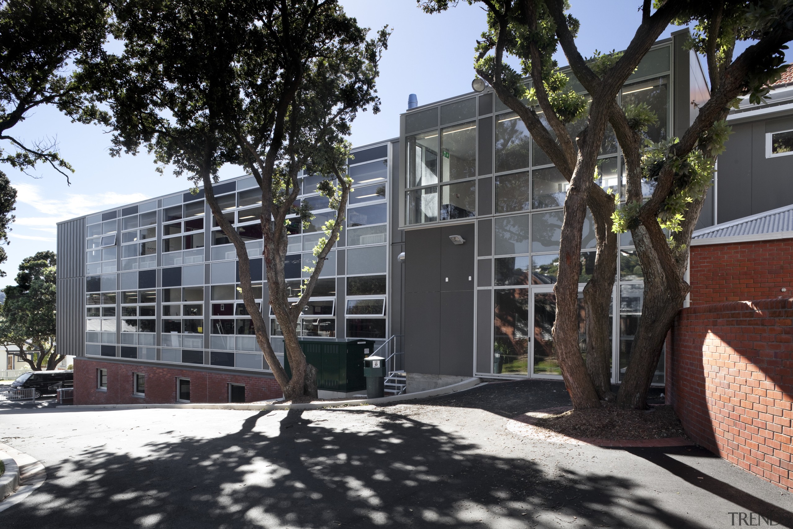 View of exterior with small windows and trees. apartment, architecture, building, condominium, facade, home, house, mixed use, neighbourhood, property, real estate, residential area, tree, black