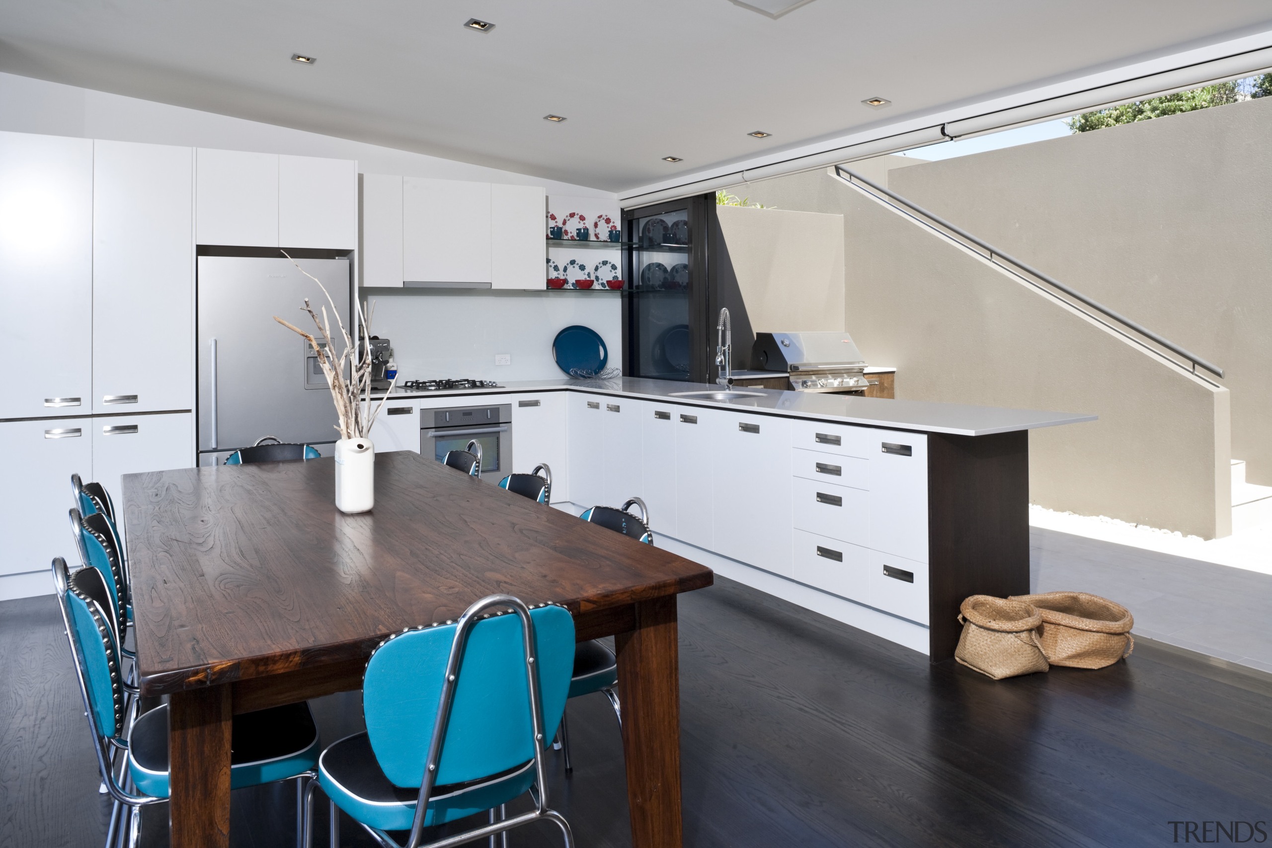 View of living space and kitchen featuring stained countertop, interior design, kitchen, room, table, gray, white