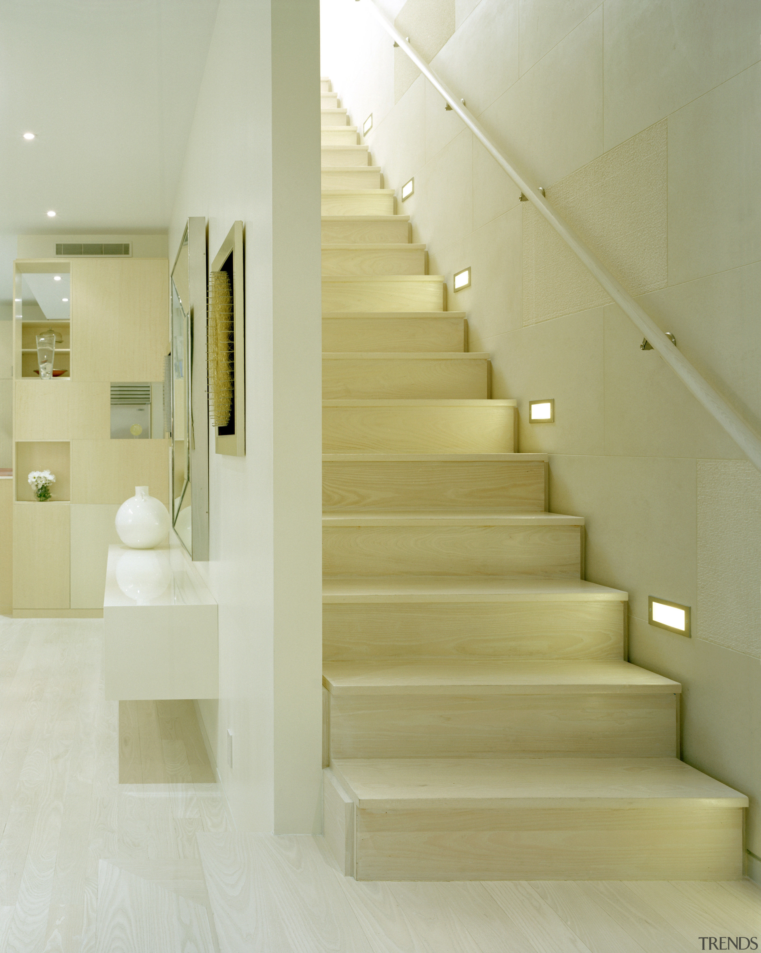 The white-on-white interior provides a tranquil refuge from architecture, daylighting, floor, flooring, handrail, home, interior design, laminate flooring, lobby, product design, stairs, tile, wall, wood flooring, yellow, orange