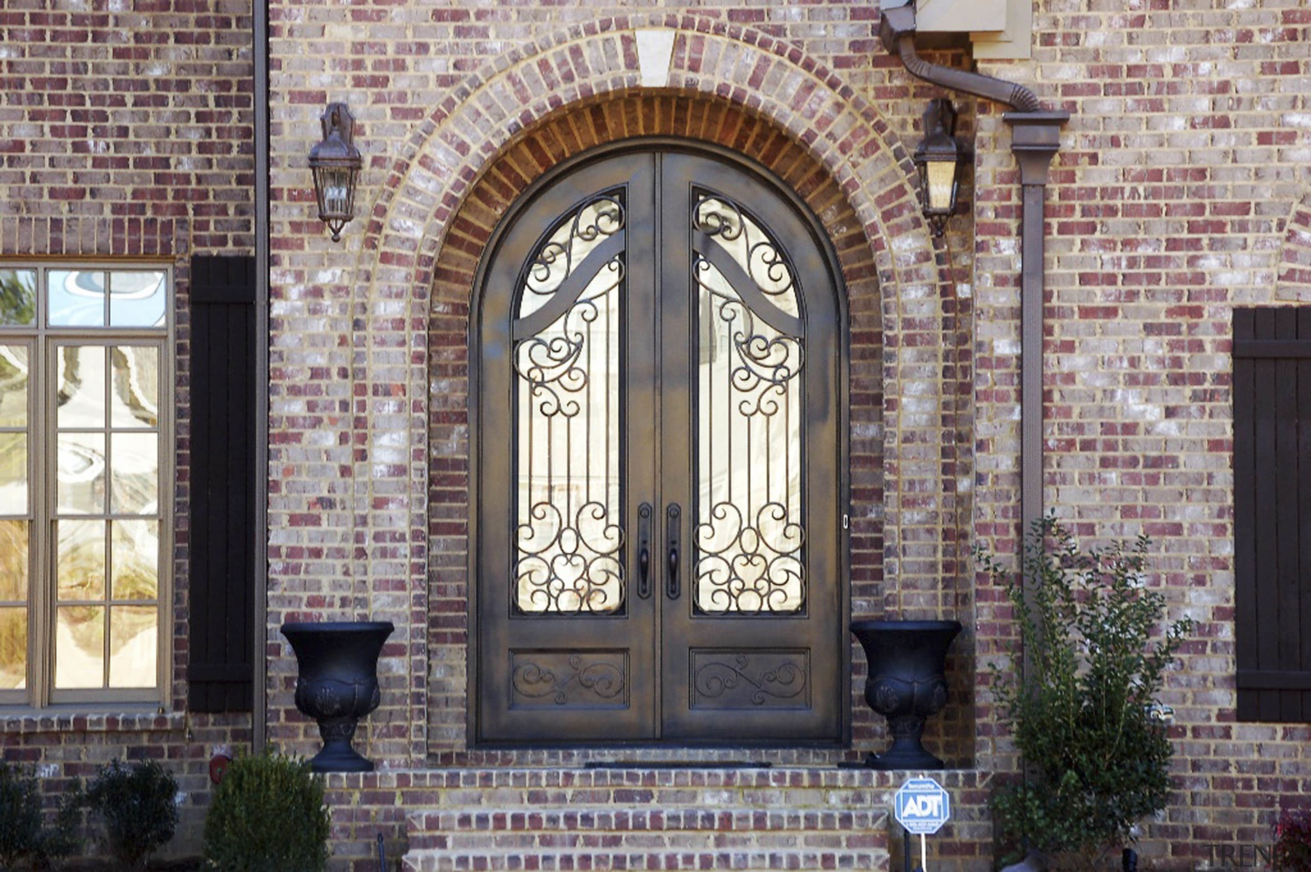 Exterior view of grand entrance way featuring Iron arch, brick, brickwork, door, facade, gate, iron, medieval architecture, place of worship, window, gray