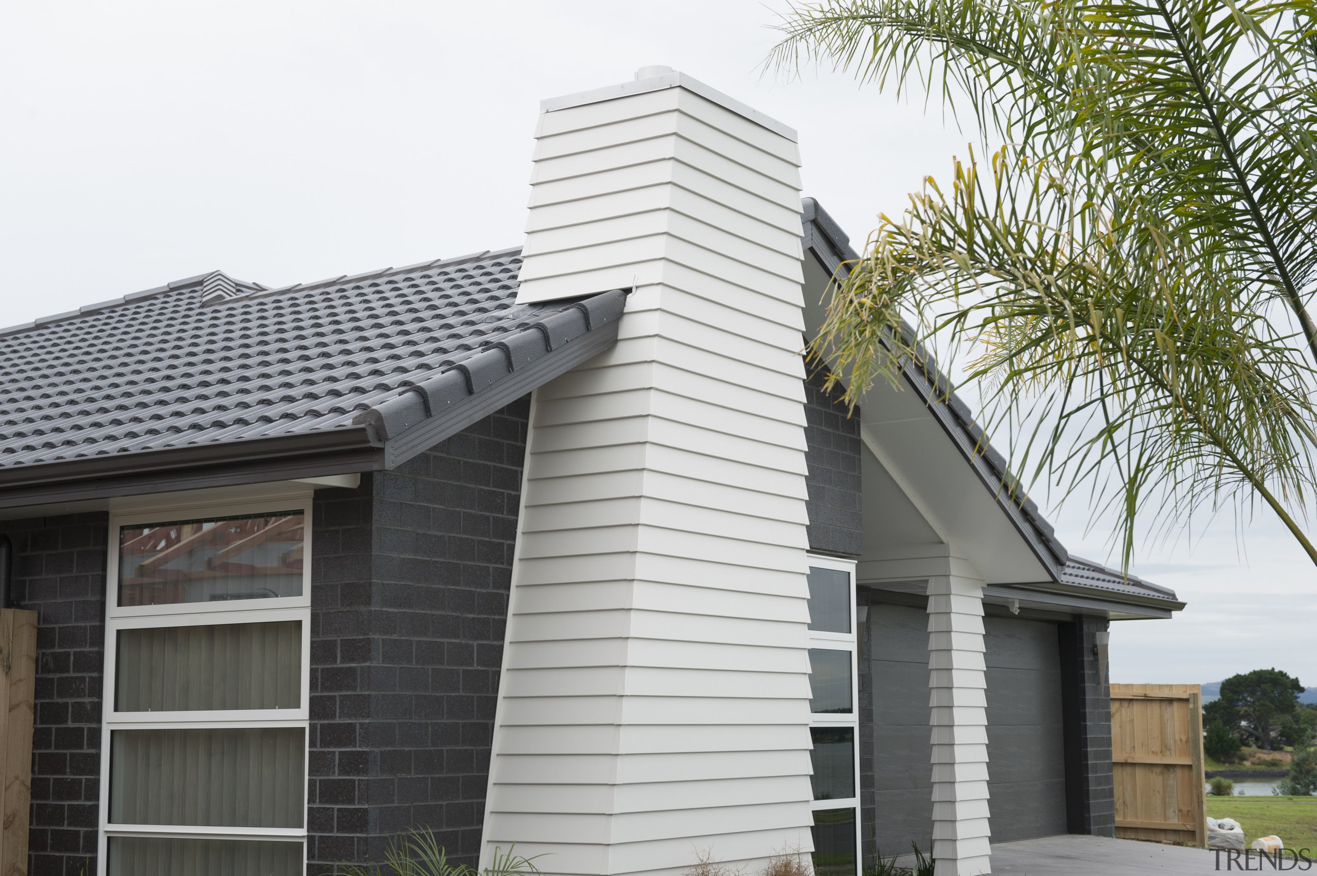 Exterior of single-storey house, dark stone cladding, and building, elevation, facade, home, house, property, real estate, residential area, roof, siding, window, white